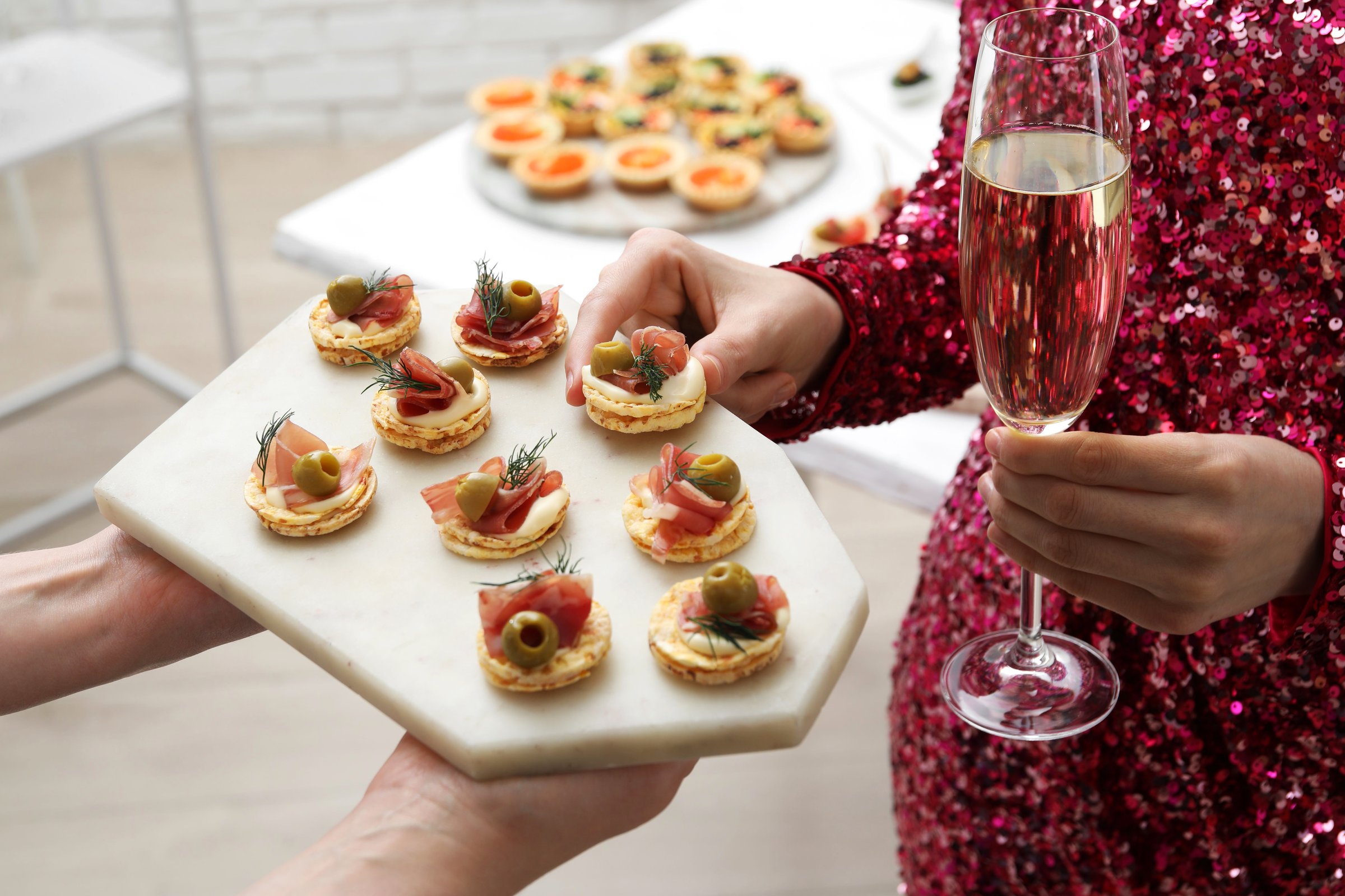 Woman taking tasty canape from waiter with board indoors, closeup