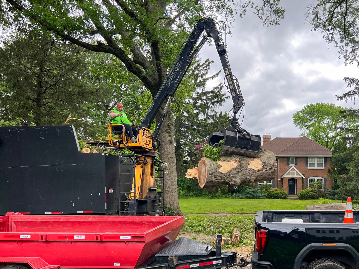 Springfield, Illinois, USA : May 21, 2025 Environmental cleanup following a natural disaster. Crew uses heavy equipment to remove a large tree that has fallen following severe storms. Residential neighborhood on a city street.