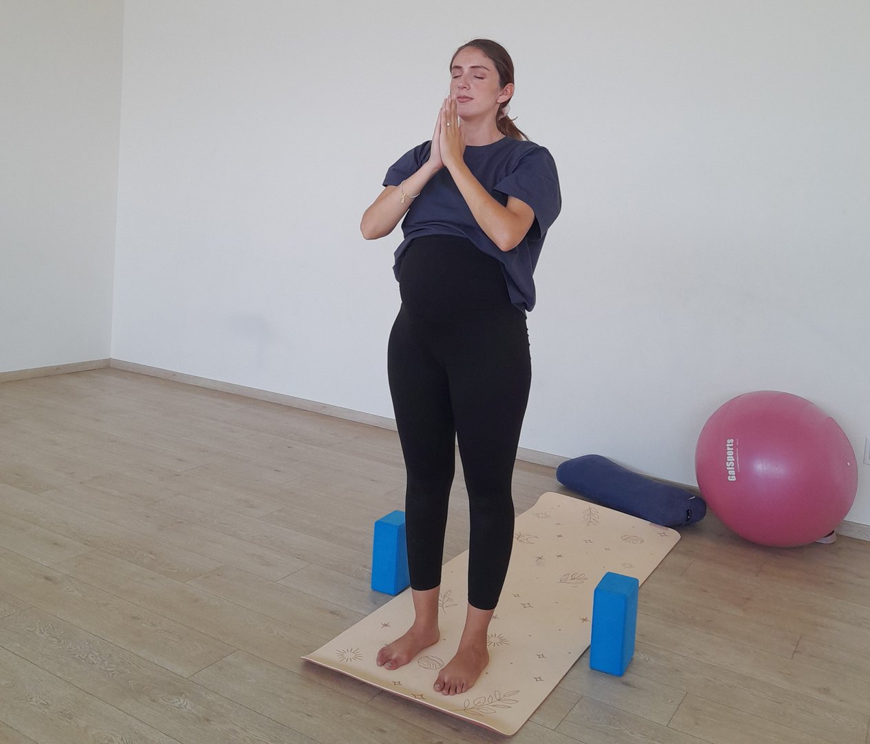 Instructora de yoga prenatal en postura Tadasana