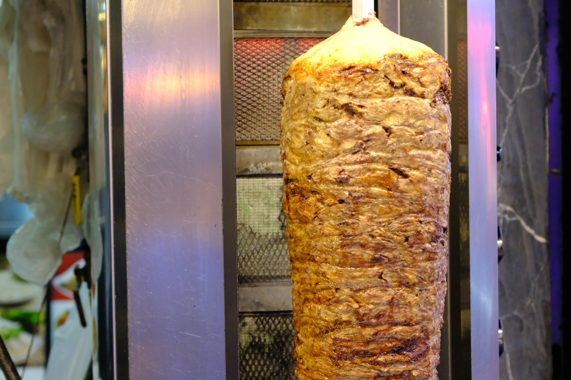 A traditional Turkish street food, döner kebab is meat cooked over a hot fire. Turkish fast food. Healthy eating. Local dishes. Delicious lamb döner kebab.