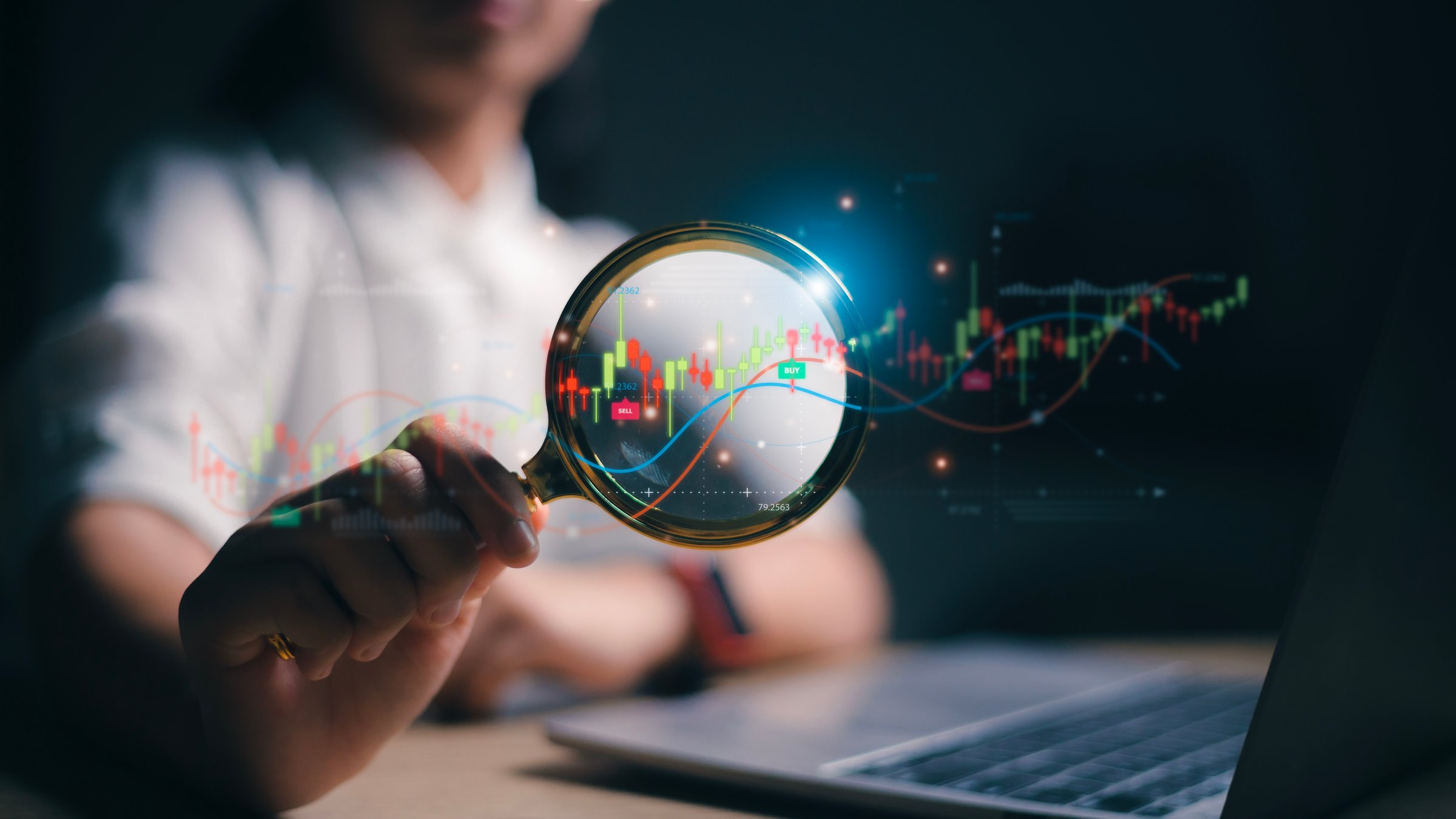 Woman hand holding magnifier glass with virtual stock market chart, Business investment earning income concept. stock market for analysis technical grap.