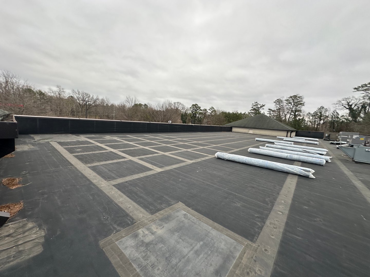 An aerial view of a construction site featuring workers on a flat roof