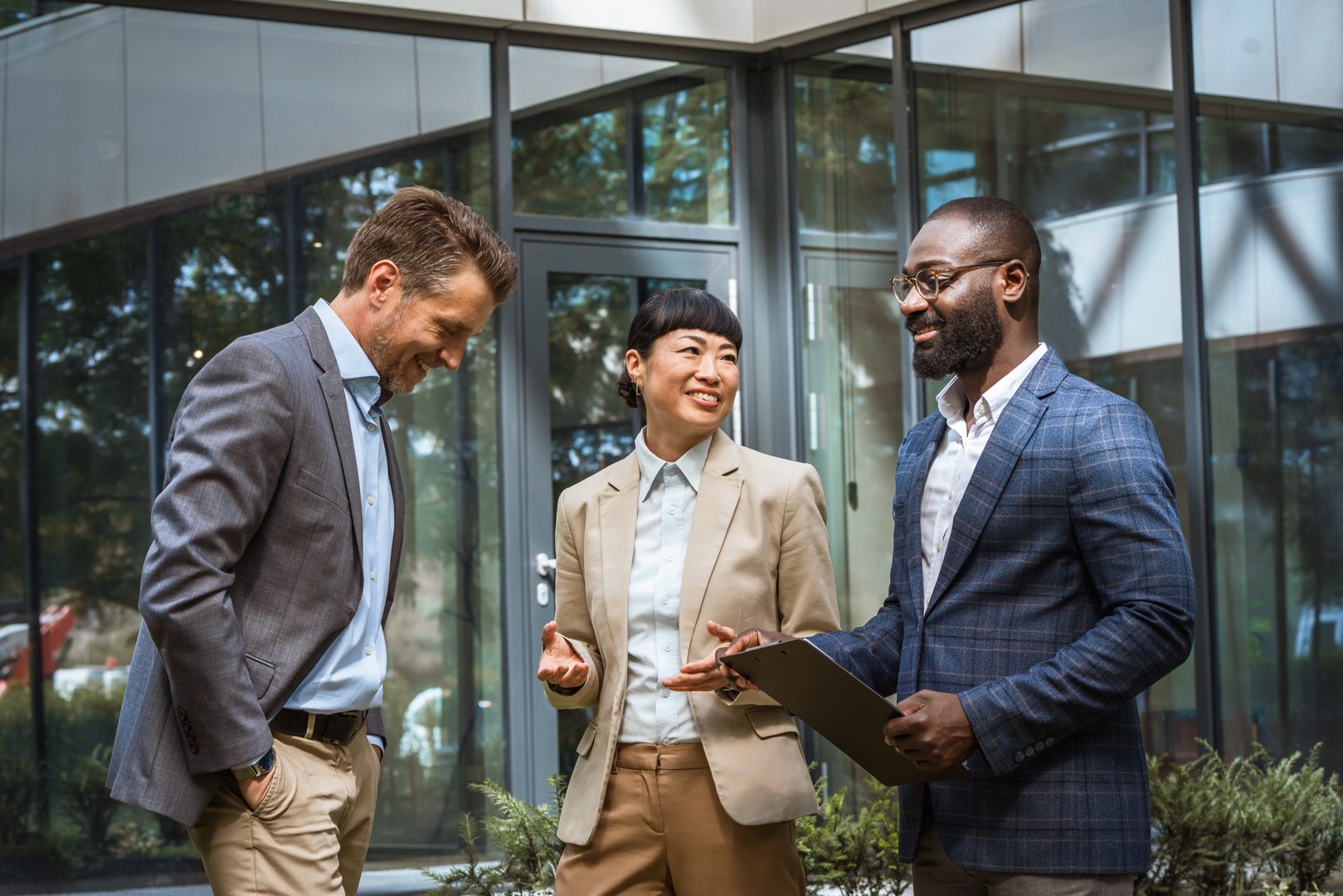 Multicultural business team having a discussion outdoor in front modern office building