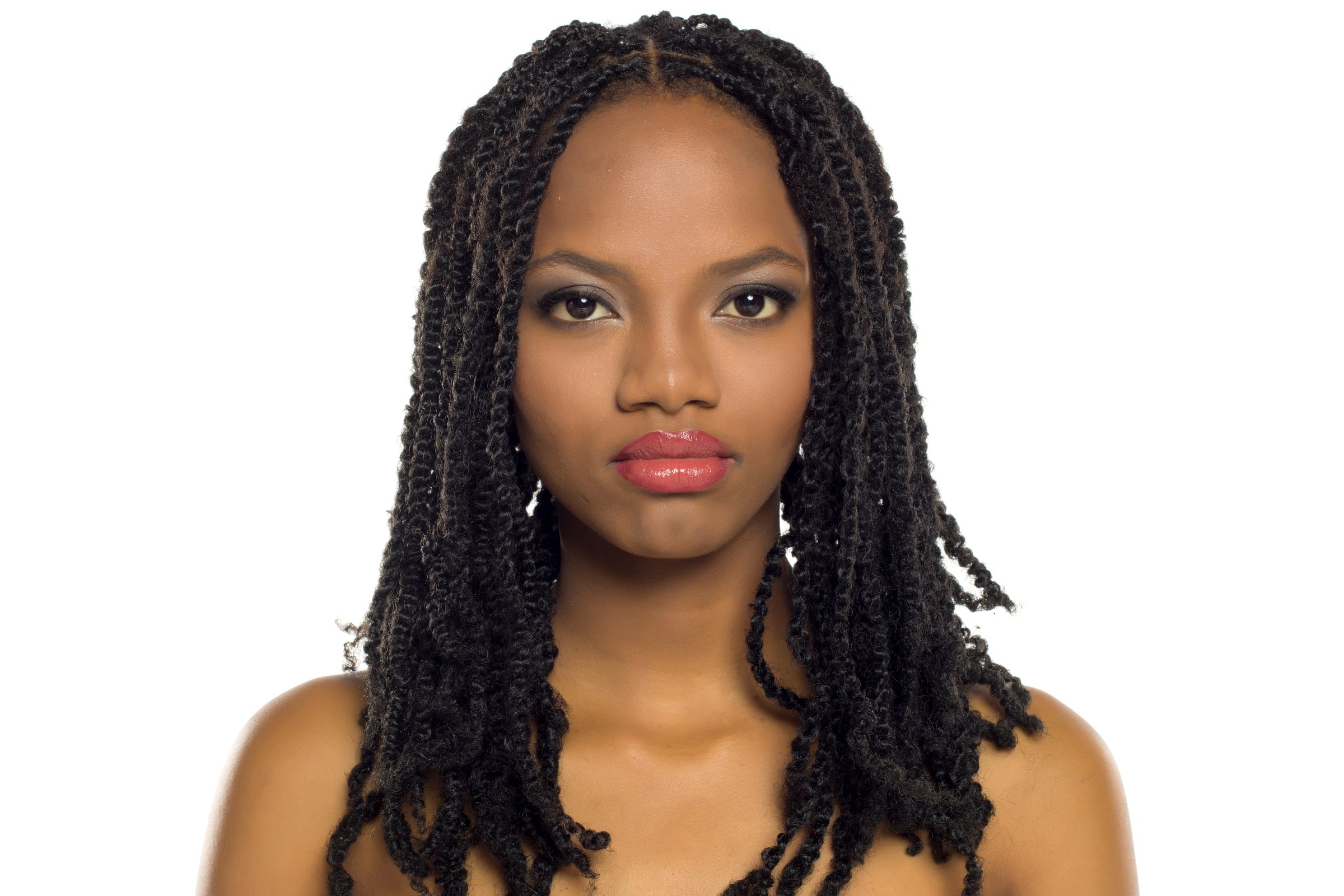 Front portrait of a serious black woman with braided hair and elegant makeup, studio shot on white background
