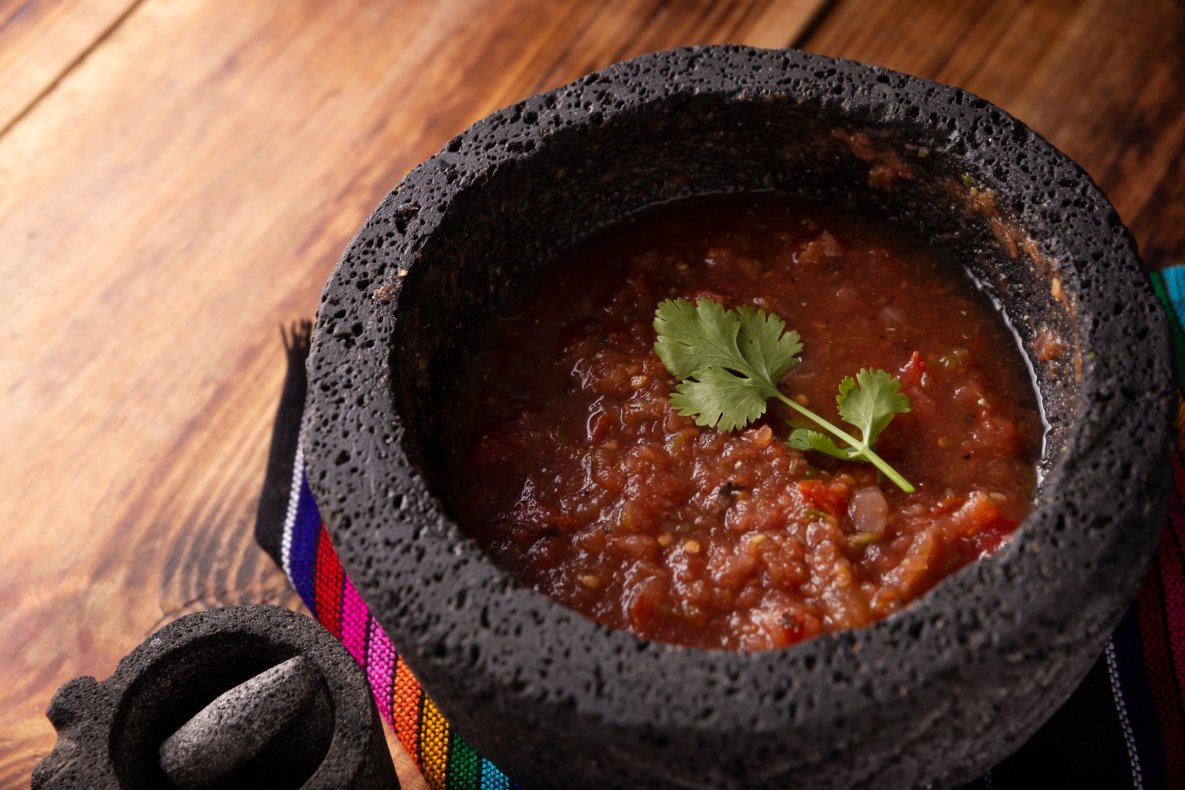Salsa Roja de Molcajete. Traditional mexican version of mortar and pestle handmade of volcanic stone. Essential element in the preparation of the authentic Mexican sauce