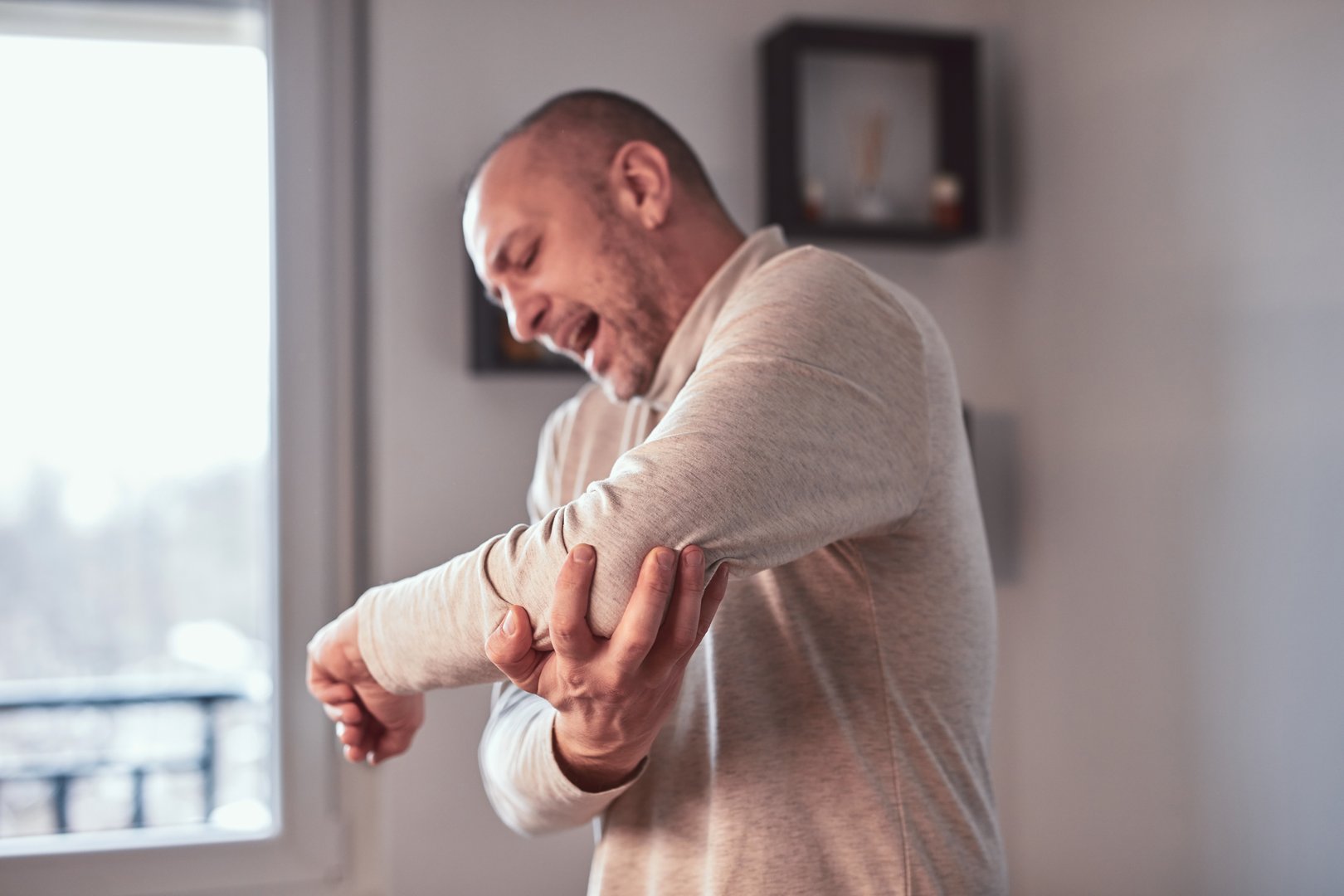 Man with elbow pain at home