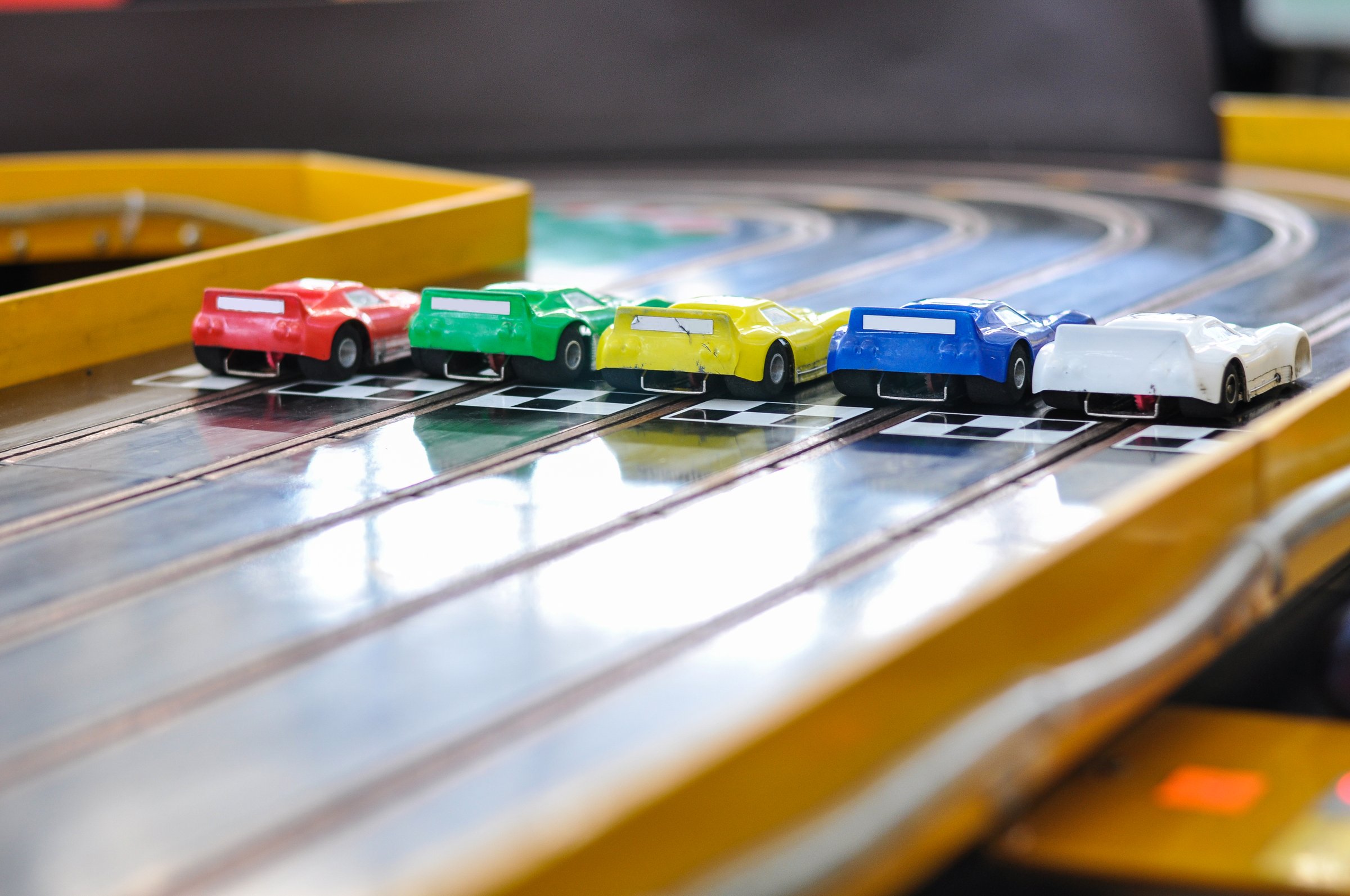Slot car racing. Five cars with damaged bumpers at the start. Back view