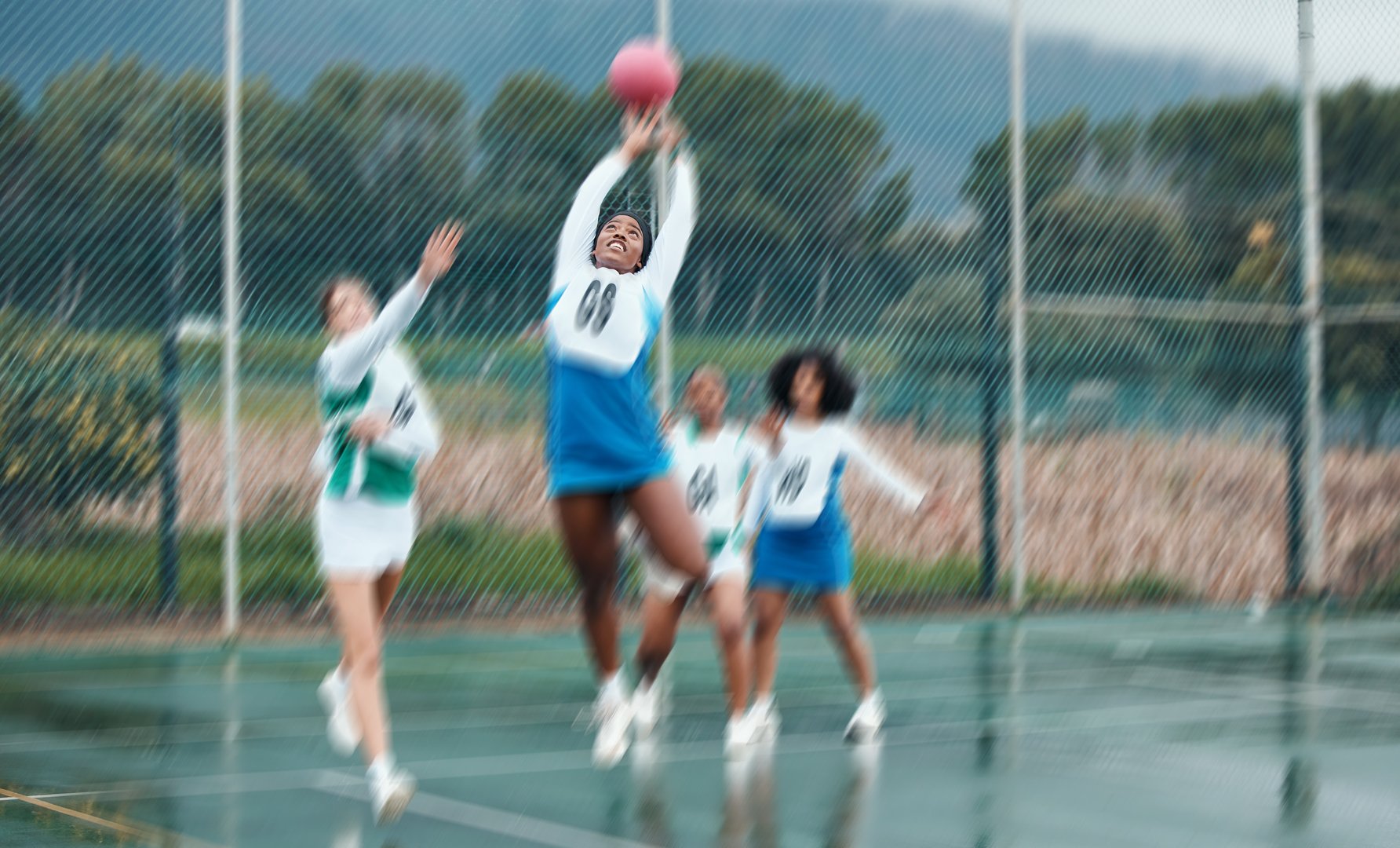 Sports team, netball player and woman jump for ball, competition and women playing game, court challenge or active match. Motion blur, action and group workout, exercise and player training together
