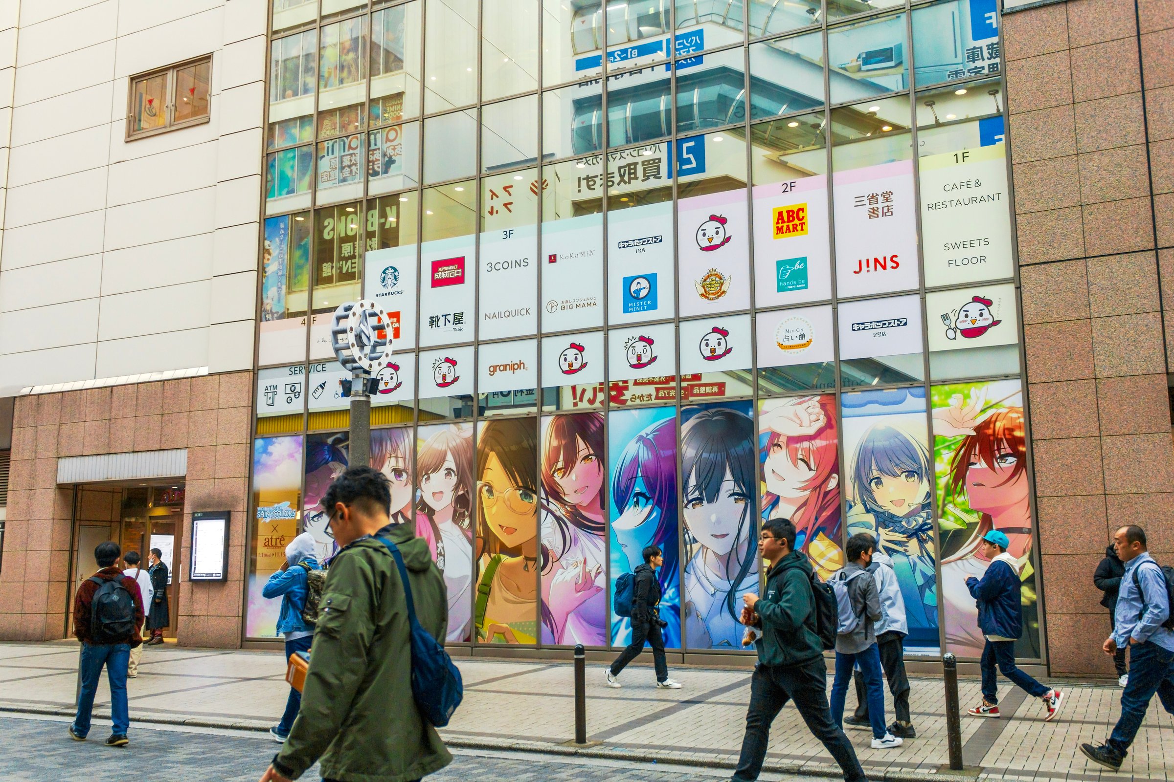 Tokyo, Japan - November 11, 2023: People walk past anime billboards near the shopping mall in Electric Town, Akihabara, Japan.