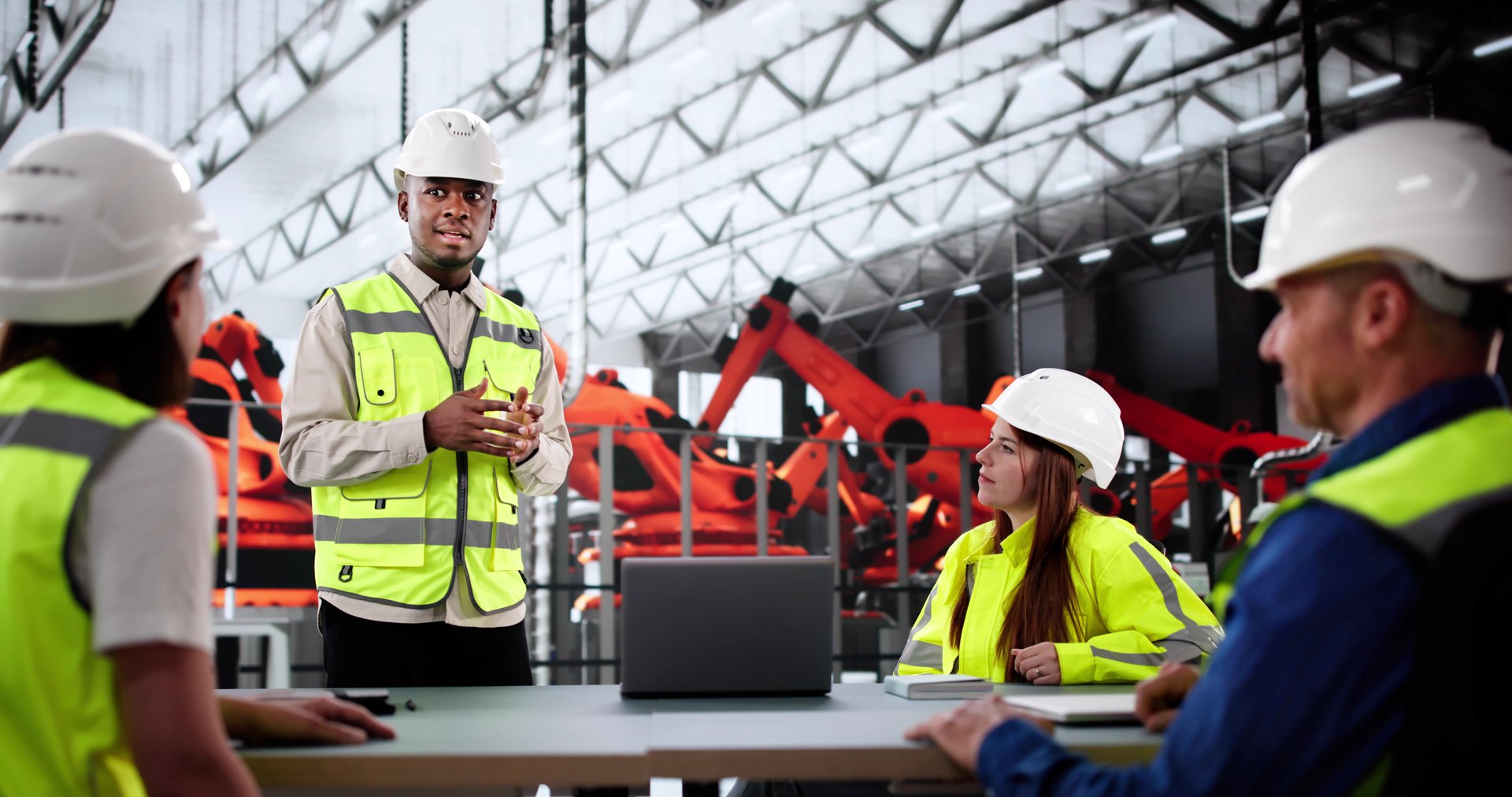 Team Of Engineers Collaborate At Production Line Inside Factory Meeting.