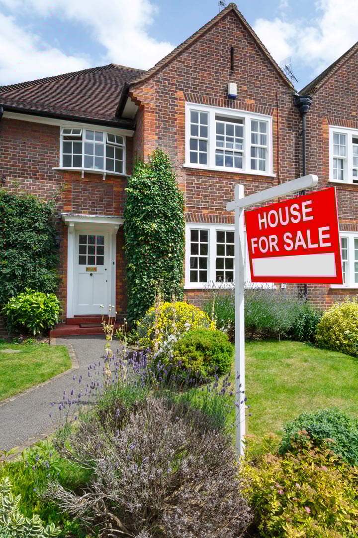 House for sale sign outside a typical UK semi-detached house in London