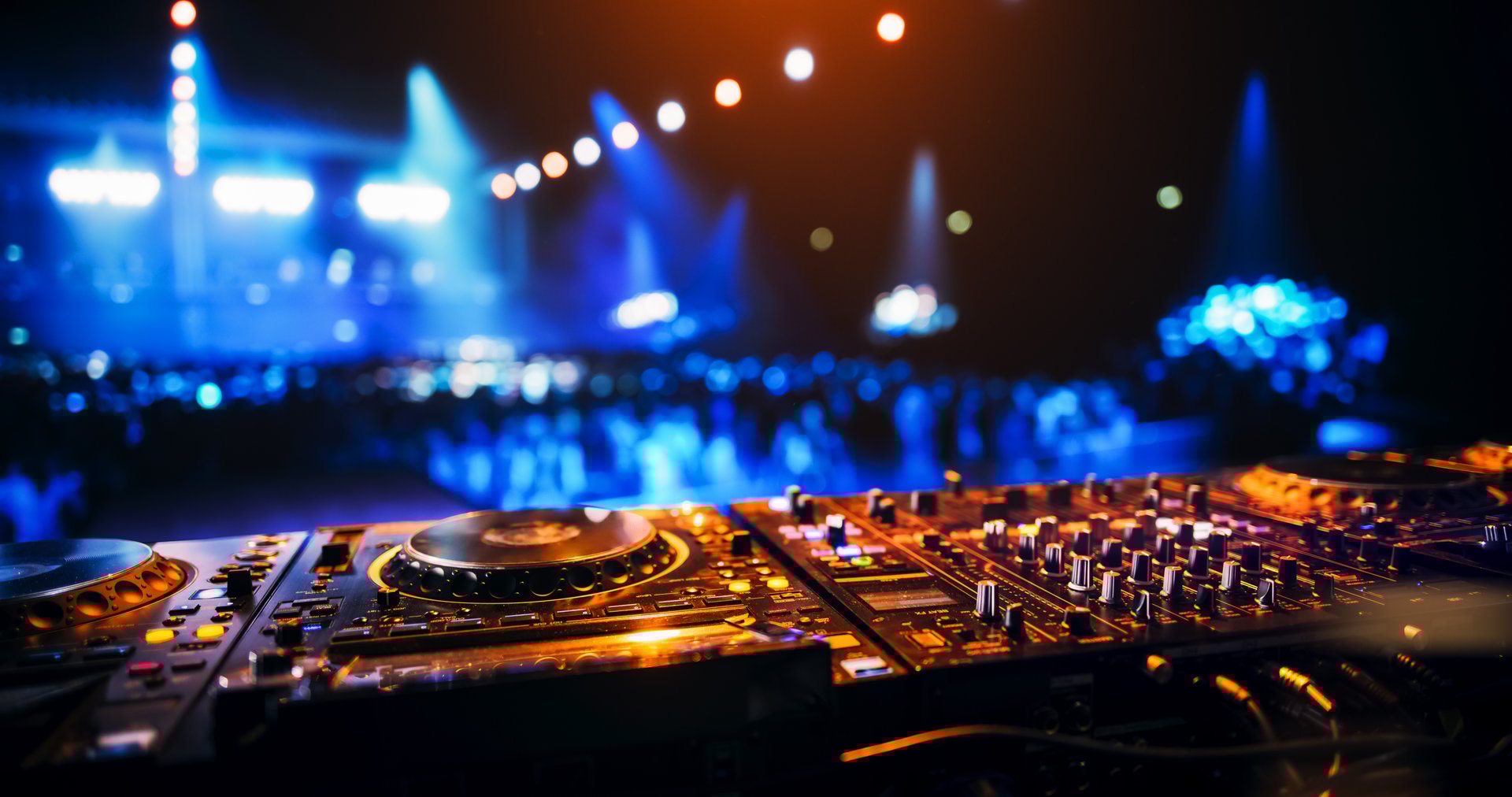 Establishing Footage with Professional DJ Equipment on a Club Stage. Mixing Decks, Controllers and Other Gear Standing on a Table, Ready to Be Used by a Popular Music Artist in Front of Audience