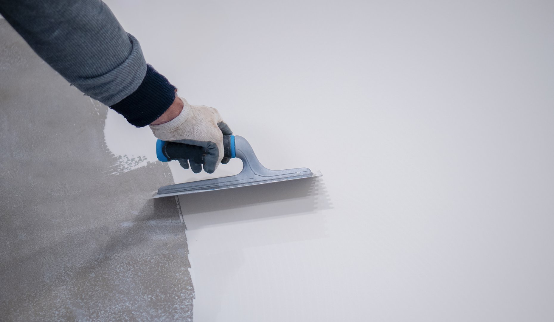 Construction worker plastering a wall using a trowel, during a house renovation