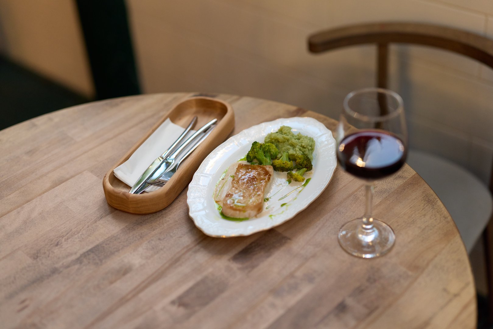 Enjoying a gourmet meal perfectly complemented by a fine glass of red wine on a beautifully crafted table