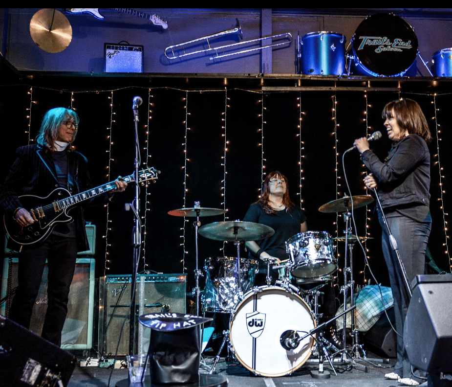 Live band performing on stage with audience and colorful stage lights
