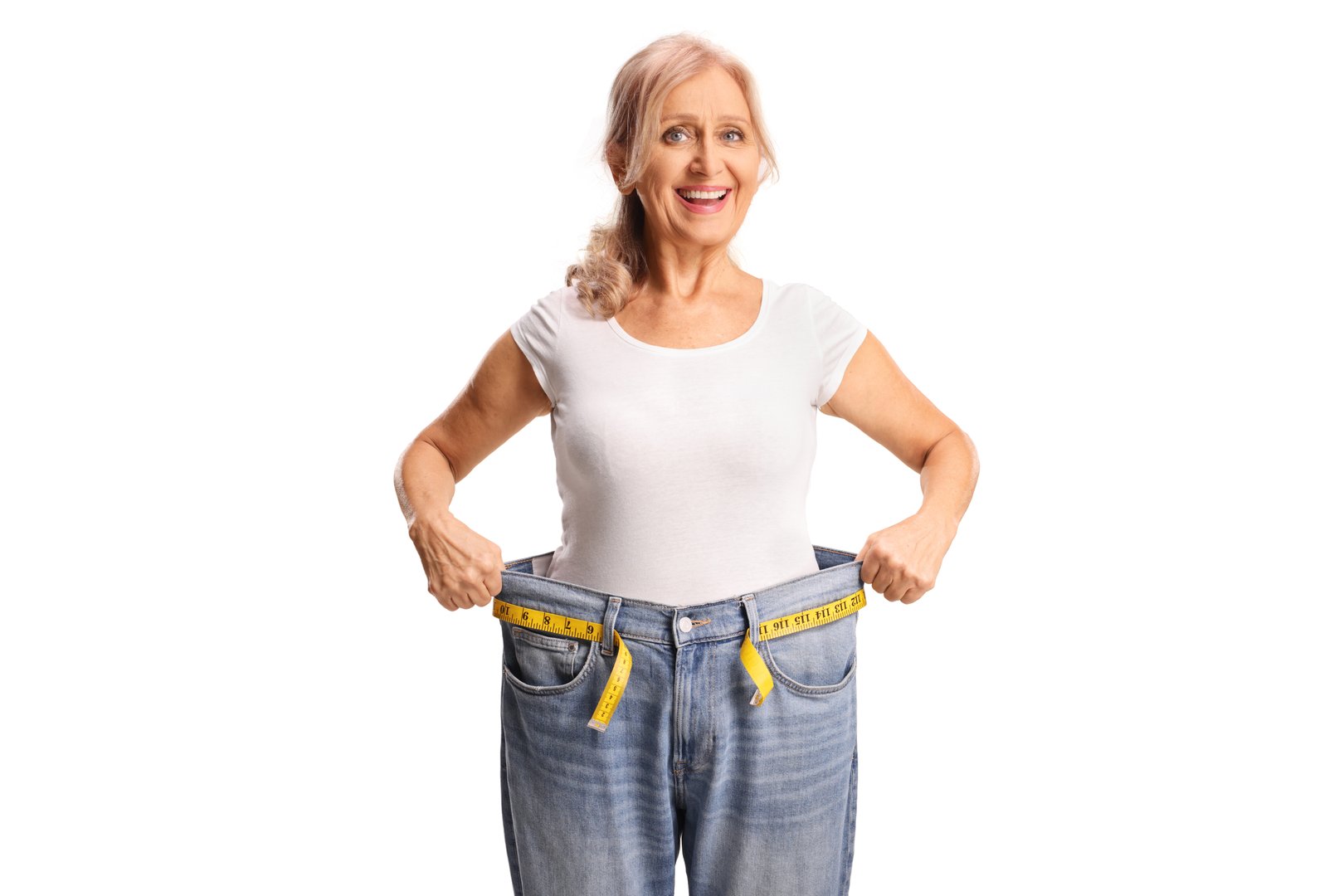 Happy middle aged woman trying on a pair of jeans, weight loss concept isolated on white background