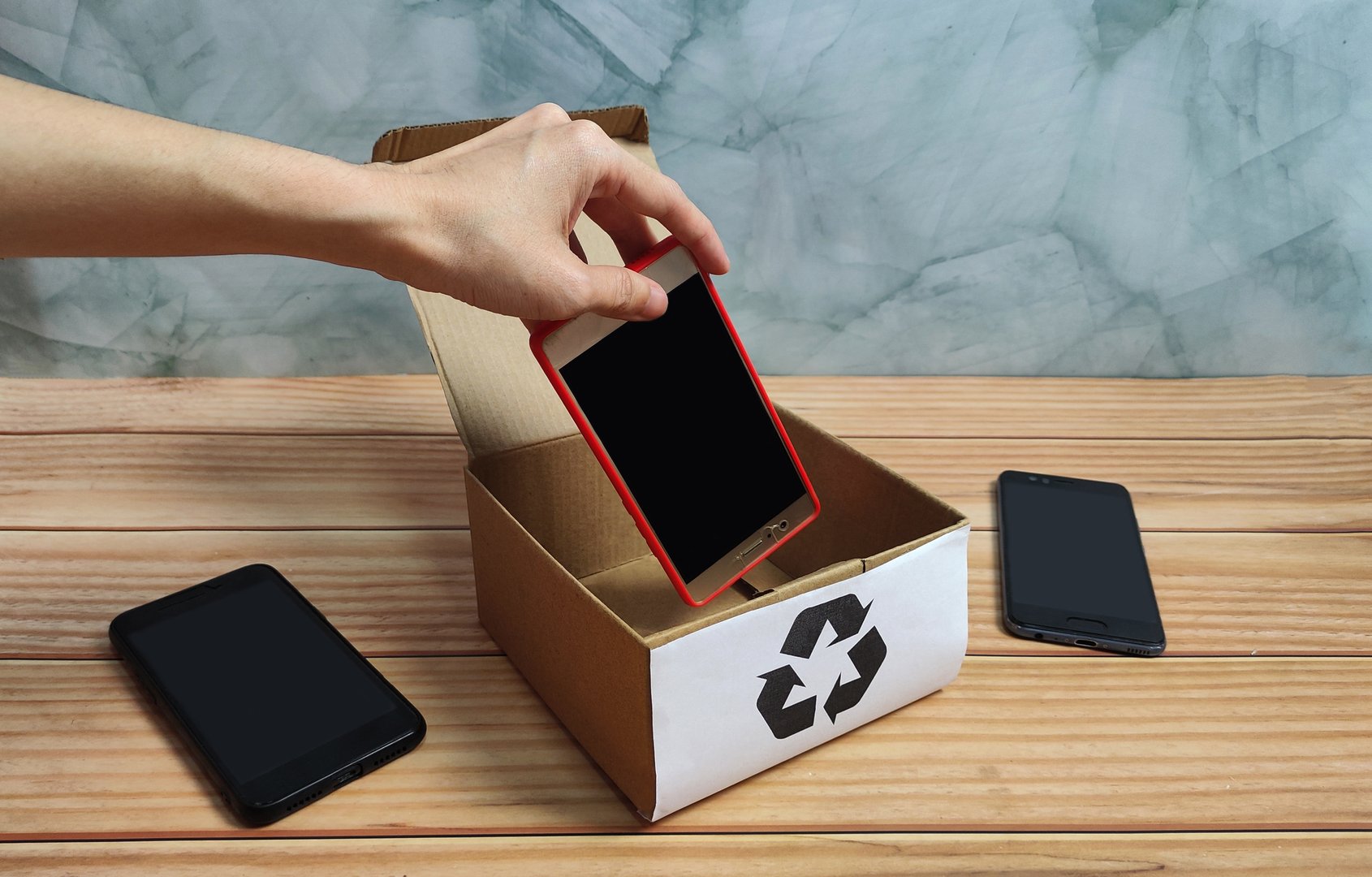 Old smartphones are carefully placed in a box at home, ready to be recycled and repurposed sustainably