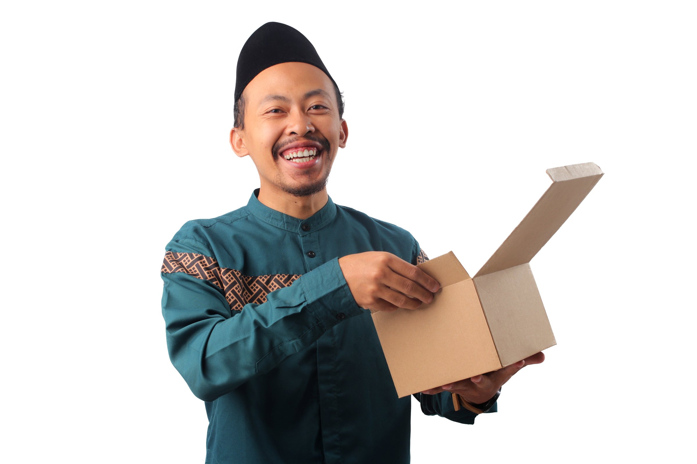 Excited Asian Muslim man carrying a stack of cardboard boxes, isolated on a white background