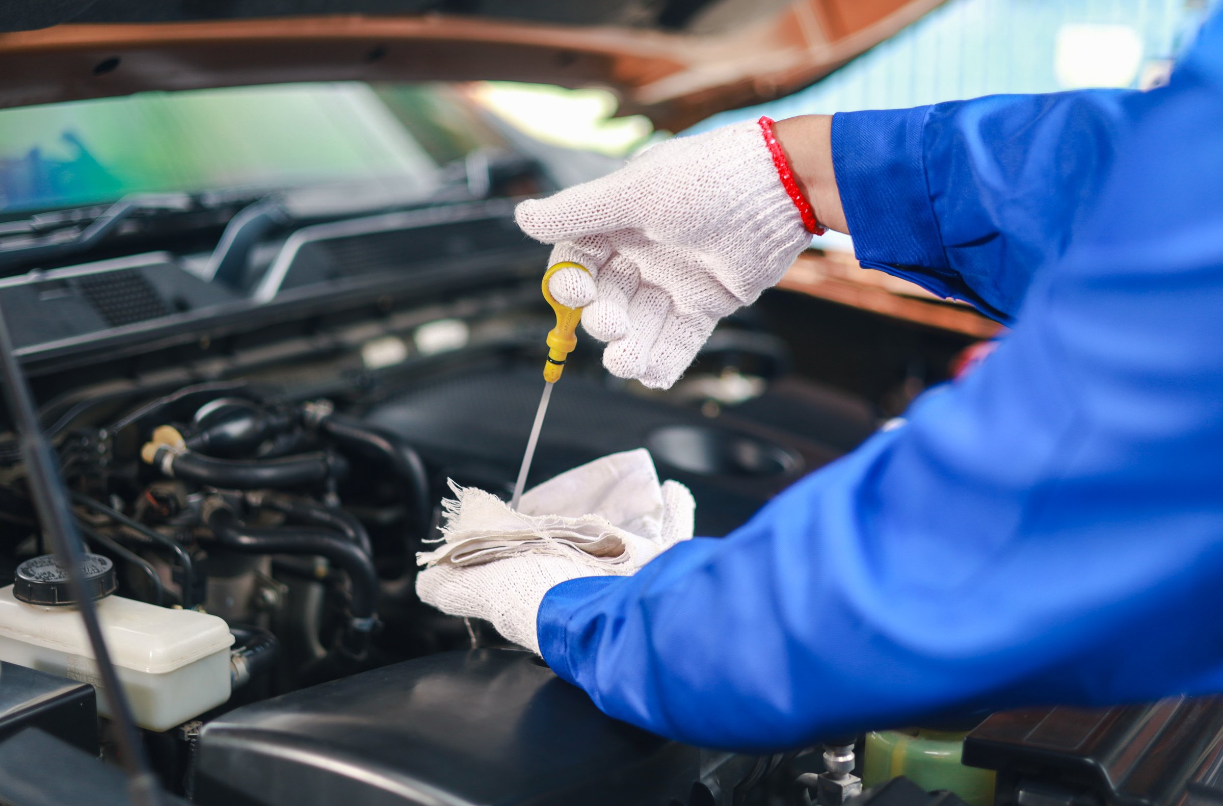 Close-up of a car mechanic checking the engine oil