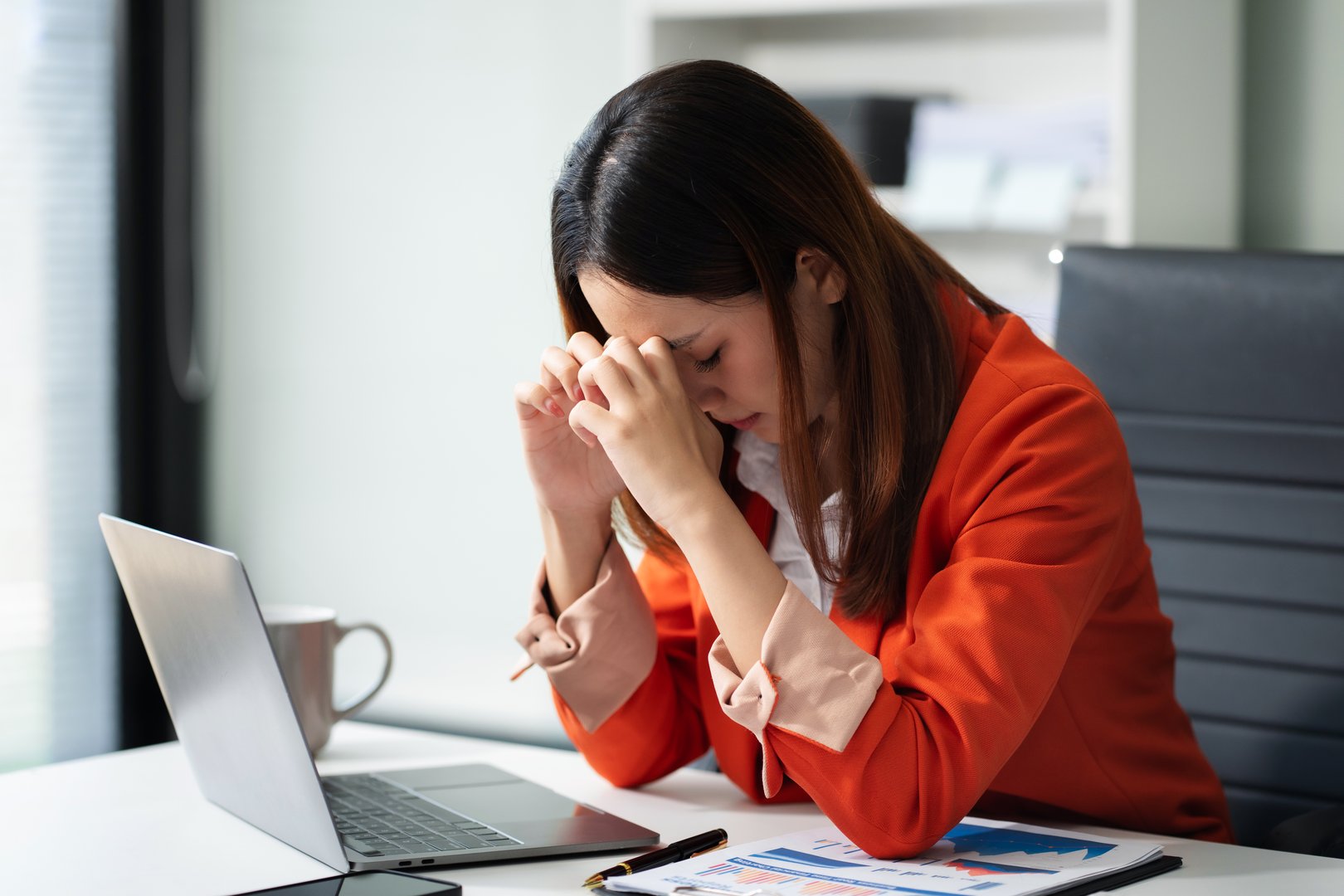 Tired asian businesswoman with headache at office, feeling sick at work.