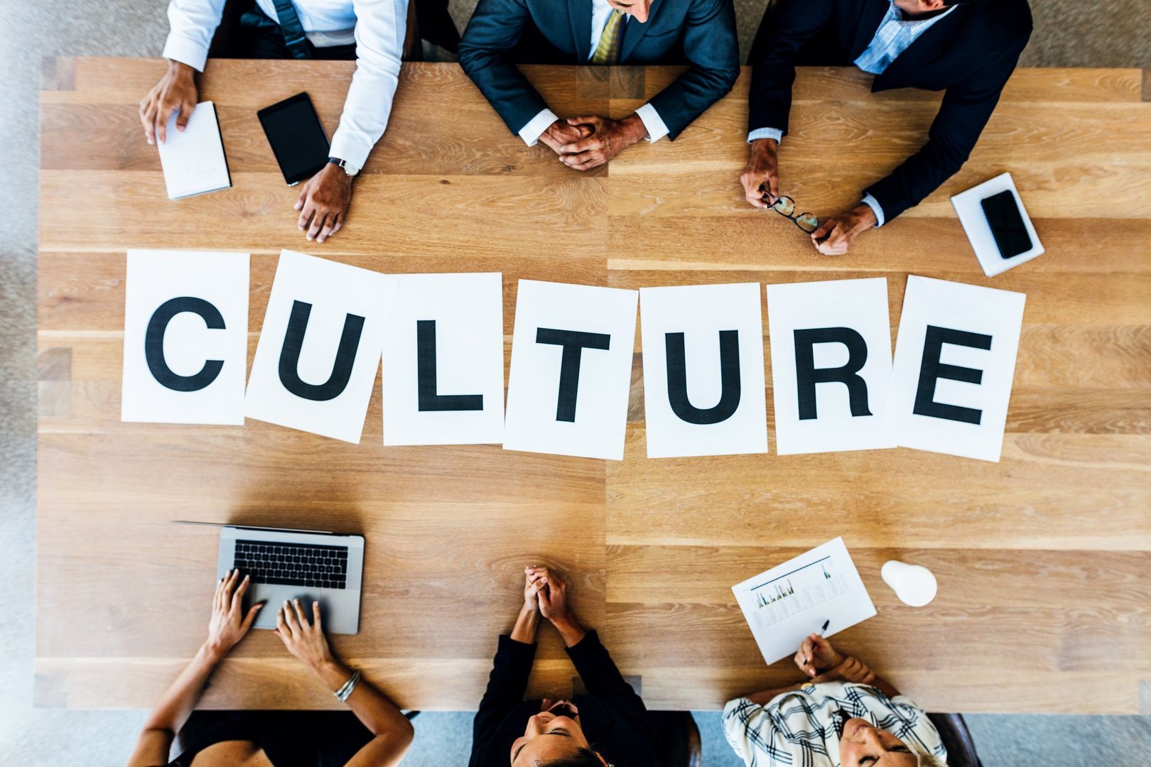 Top view of business people with word Culture on table. Business people having a meeting and discussing over work culture in office.