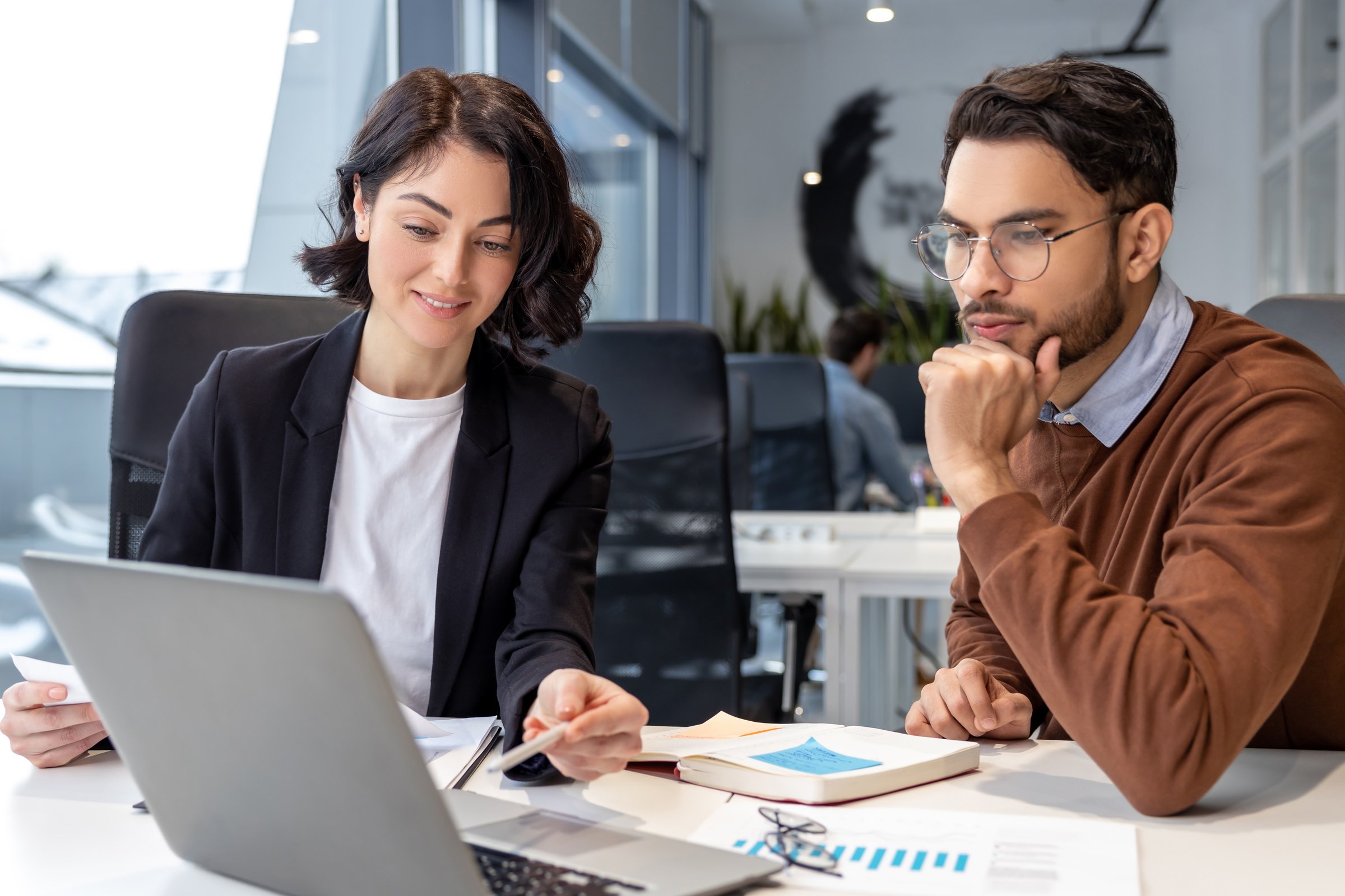 Executive colleagues using laptop for creating new business project sitting in modern office