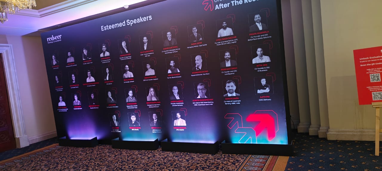 Event display board featuring photos and names of speakers, with a red text header Esteemed Speakers.