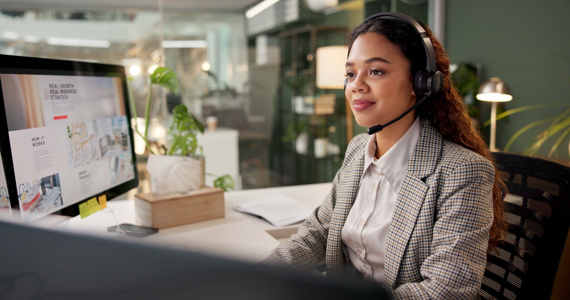 Woman, call center and smile by computer at night, headphones and advice for business growth in office. Person, agent and consultant with voip, contact or review strategy with service at workplace