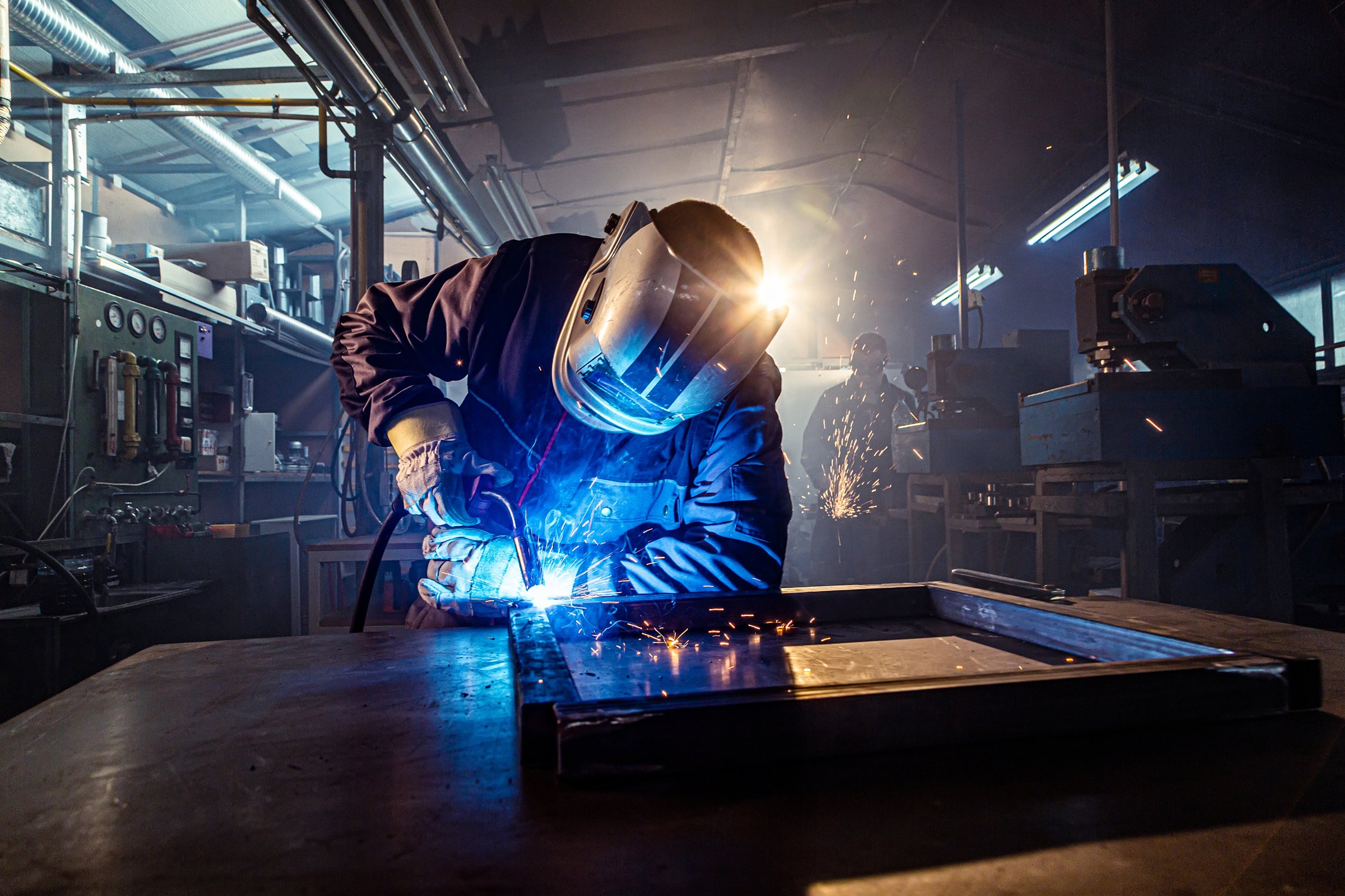 Industrial welder joining metal parts using mig/mag welding technique in a factory