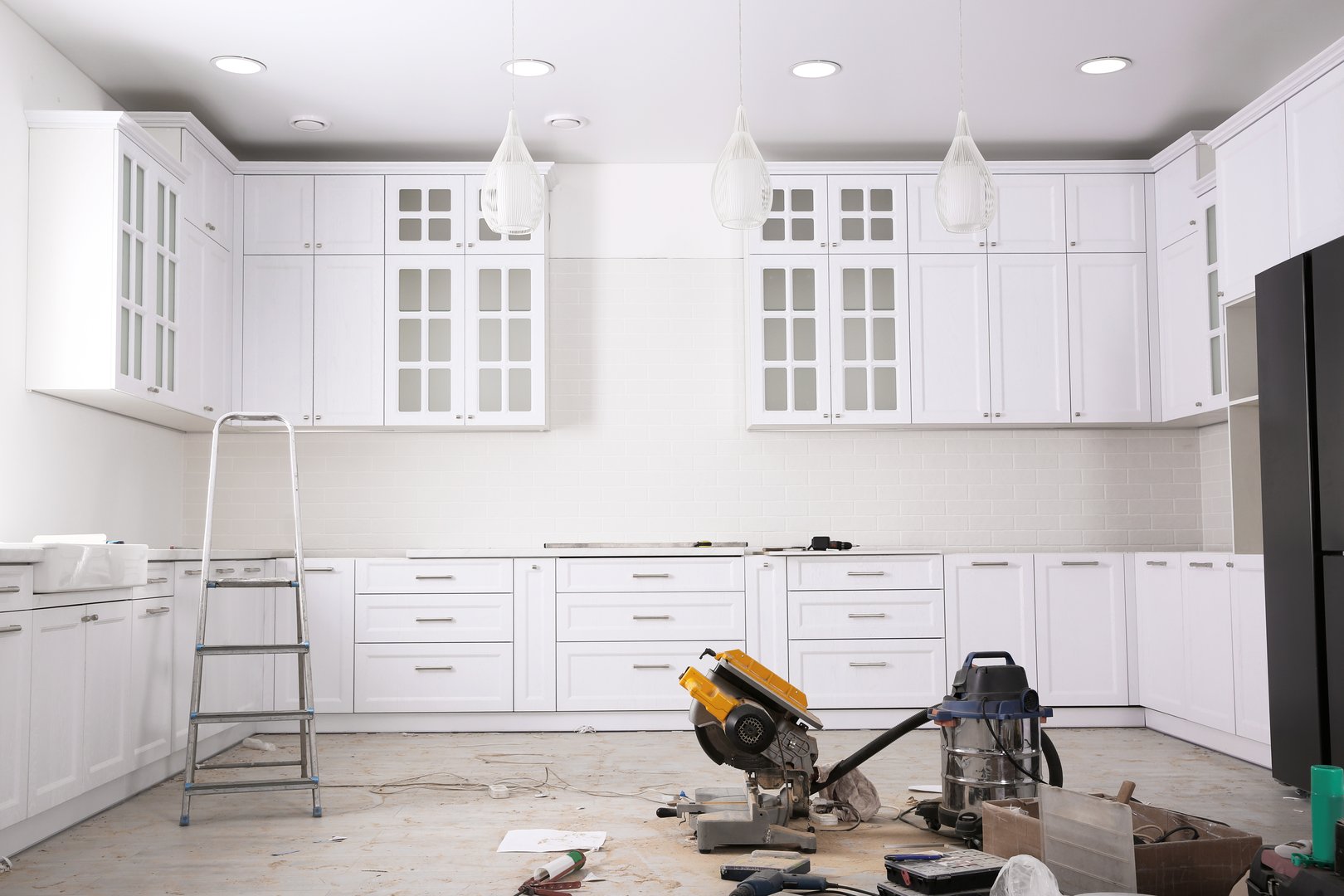 White kitchen in the process of remodeling with new cabinets. The room is clean and well lit.
