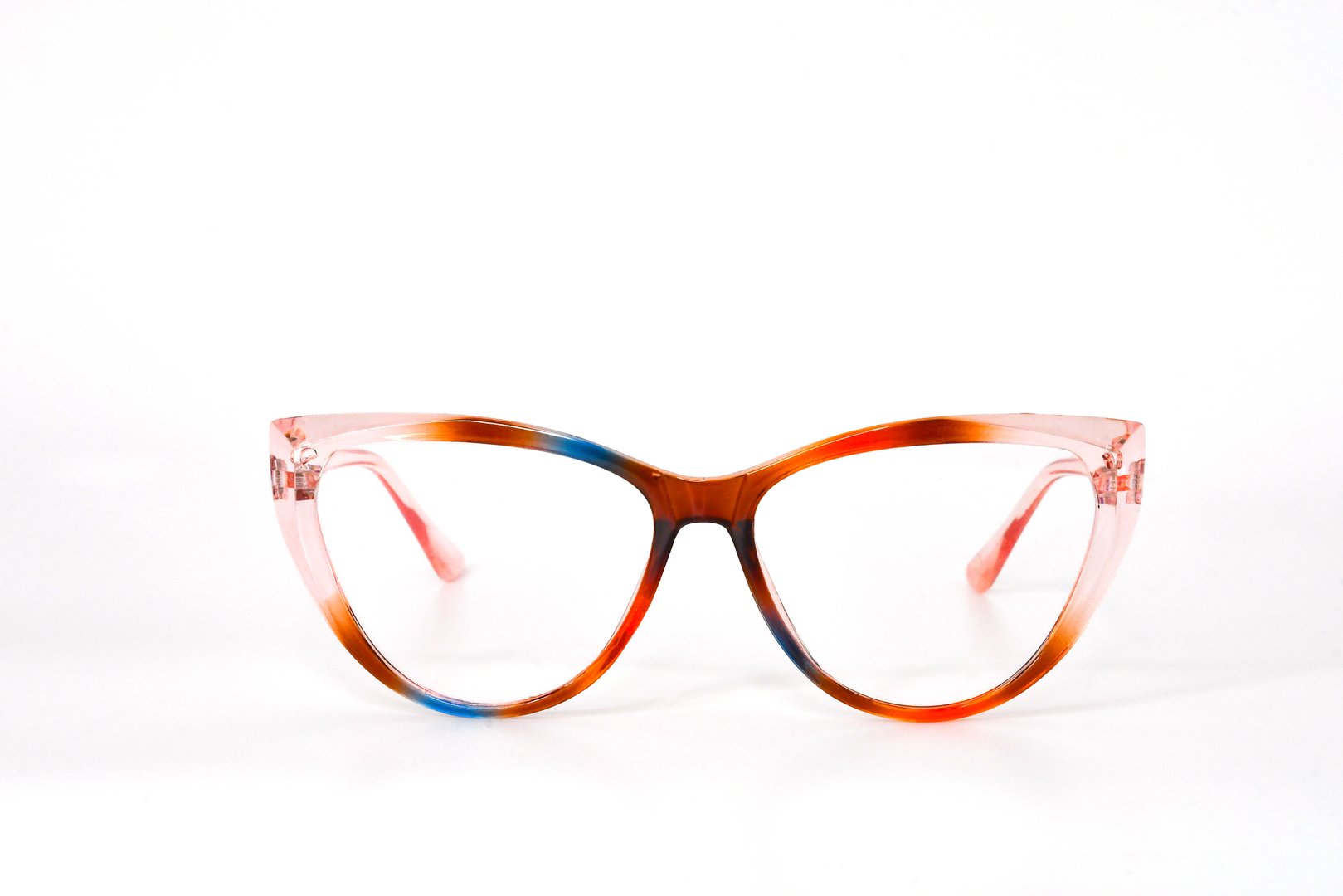 Close up front view of a pair of women's glasses with a transparent cat eye shape frame in pink, blue and brown isolated against a plain white background. Eyesight concept.