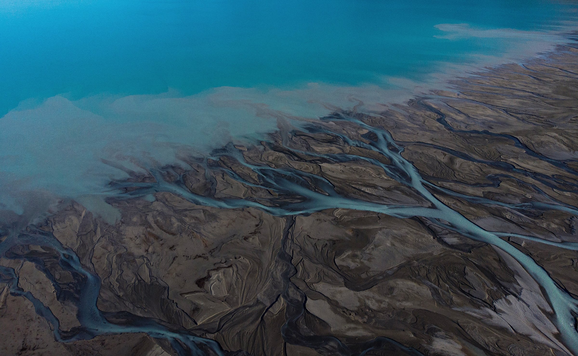 Aerial panorama view of braided river arms streams delta, glacial pristine clear azure blue turquoise Southern Alps mountain water entering Lake Pukaki, Canterbury South Island New Zealand