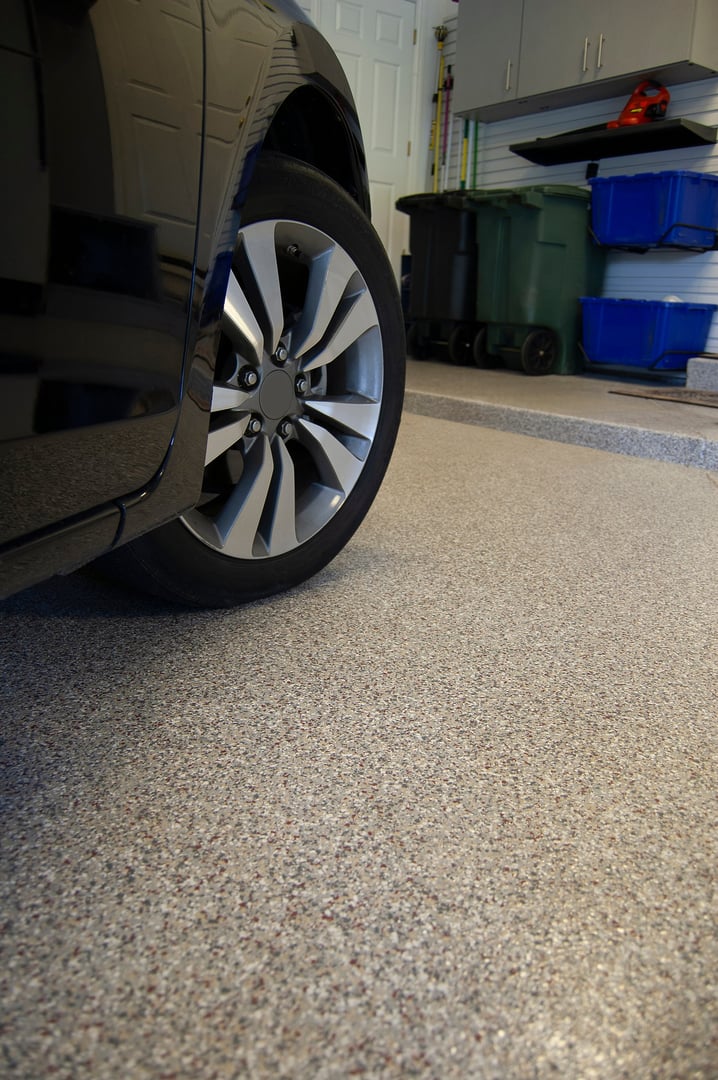 Epoxy or Polyasparitic Coating on Concrete Garage Floor with Wheel and Tire of Car visible