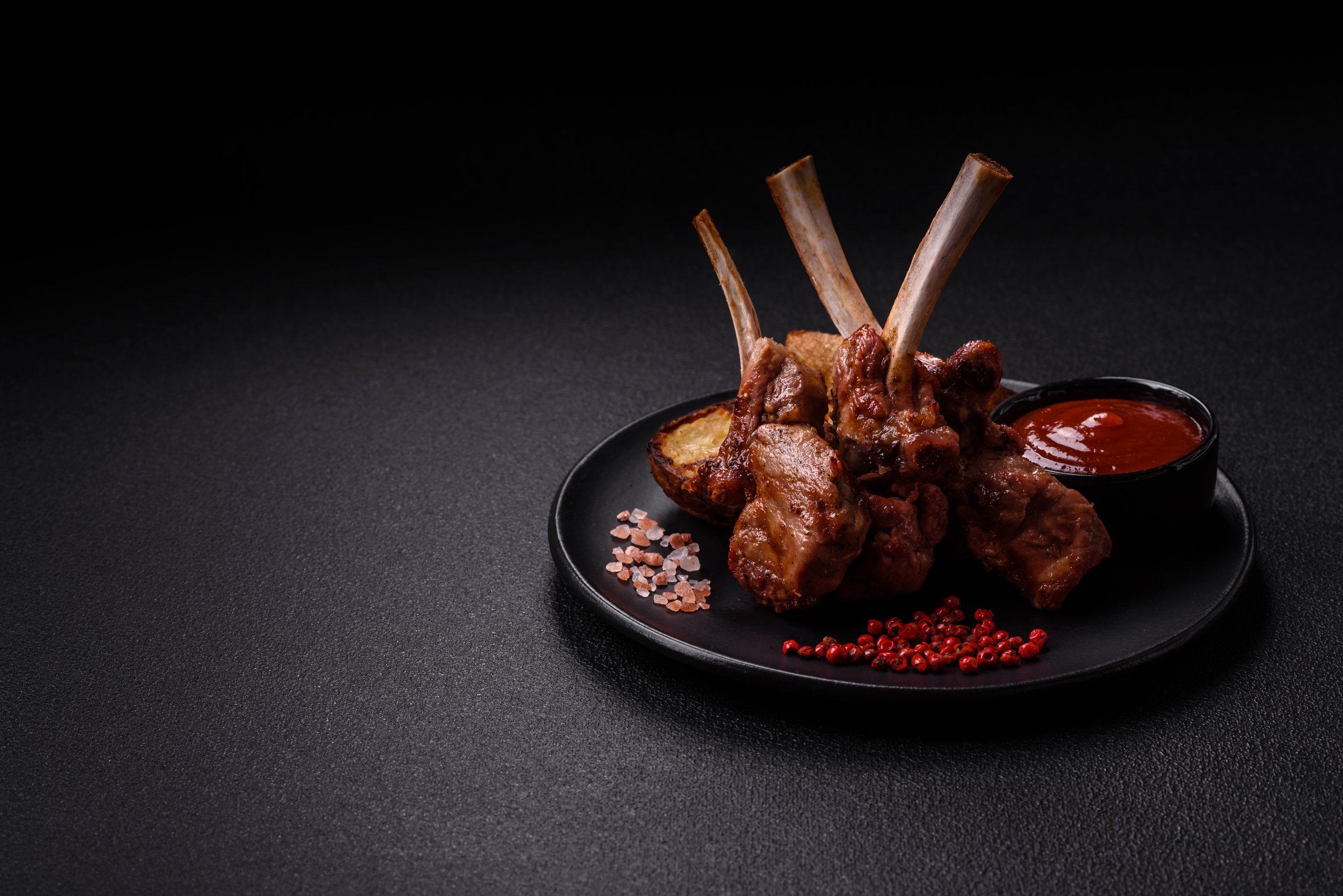 Delicious juicy meat on the bone or rack of lamb or grilled veal with salt, spices and herbs