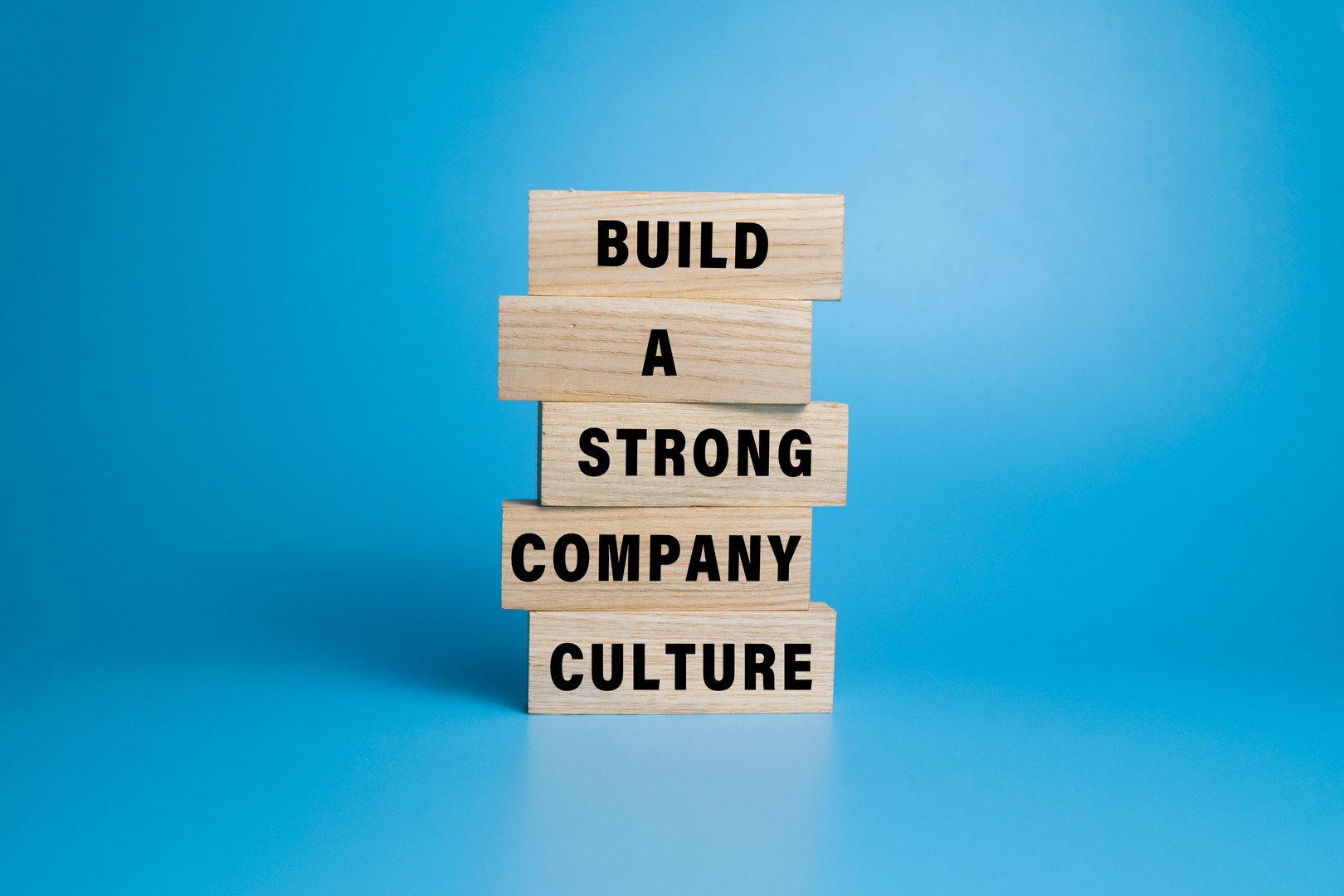 build a strong company culture words text on stack wooden blocks isolated