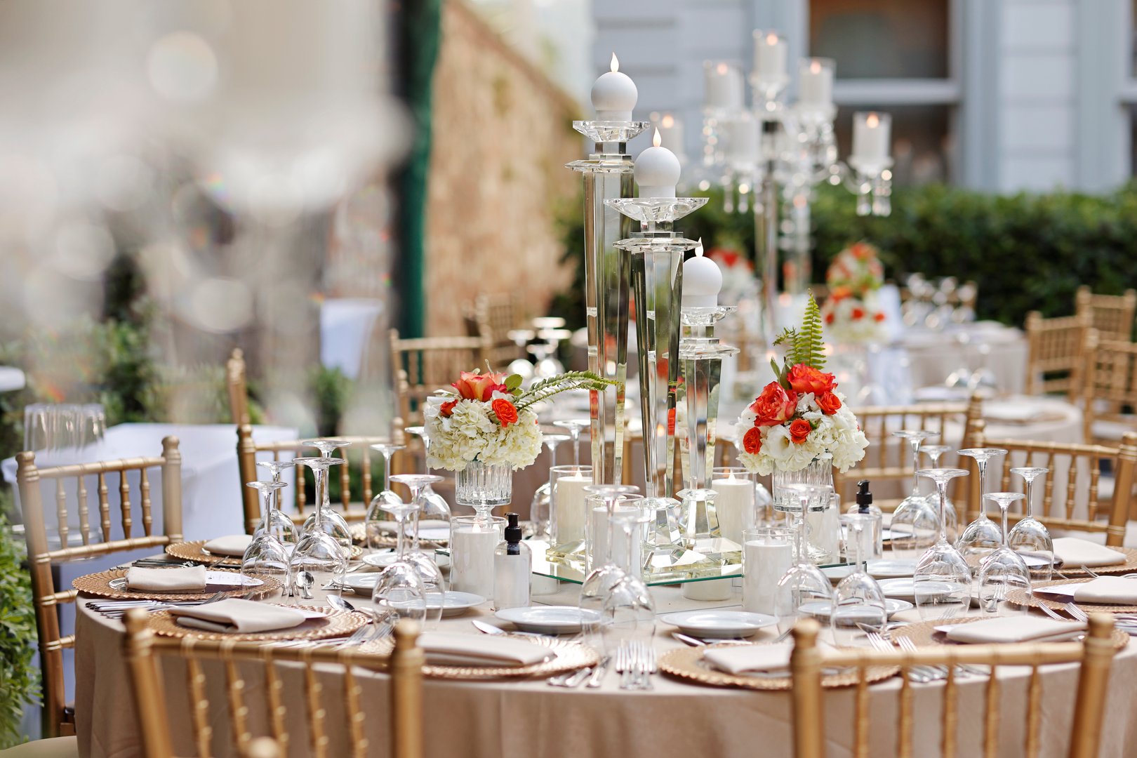 A beautifully adorned dining table prepared for an outdoor wedding, adorned with flowers, featuring crystal candelabras in the center. stock photo