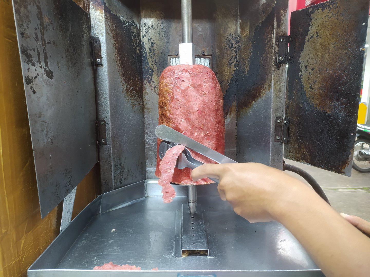 Kebab seller cutting grilled meat