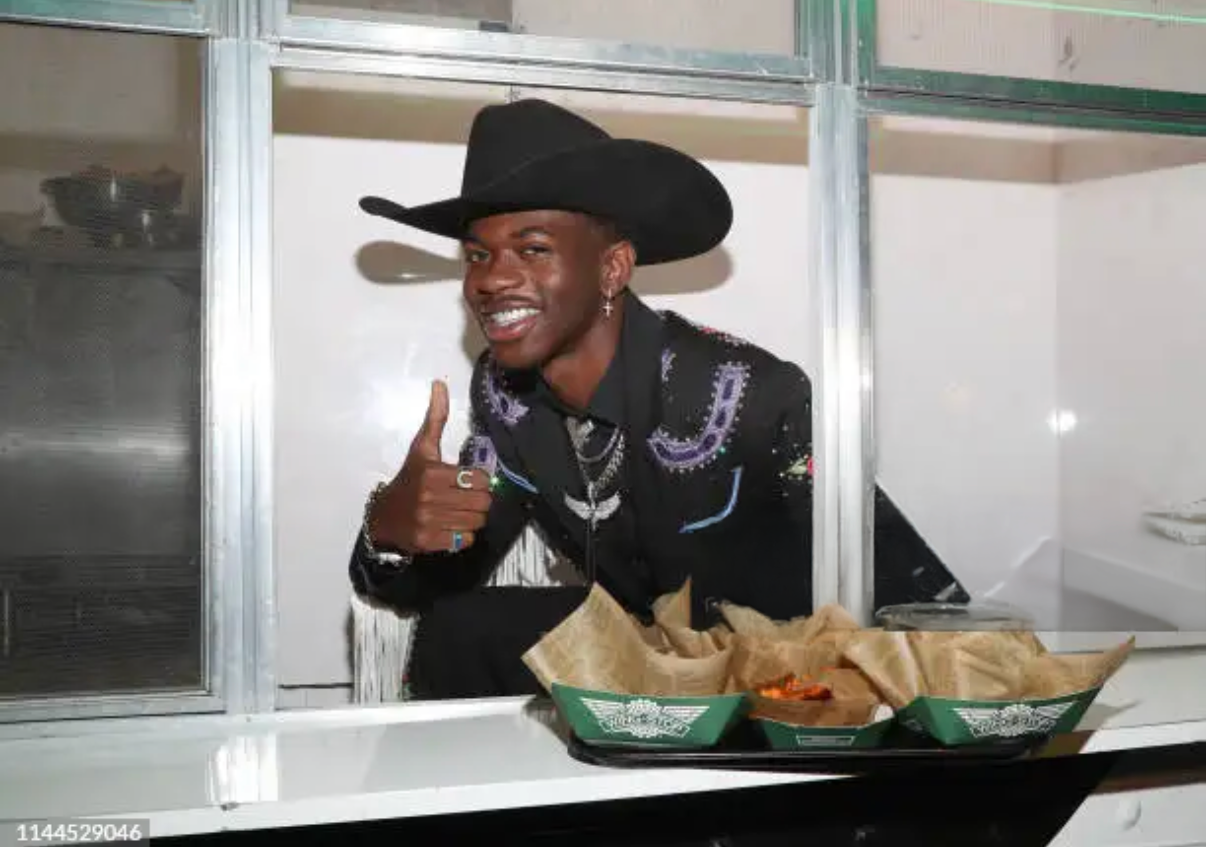 Businessman placing colorful paper notes on transparent board during team strategy session.