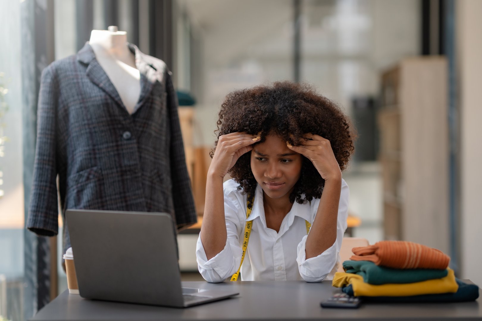 Young Young African American woman tailor designer failing and stressed in workplace office.