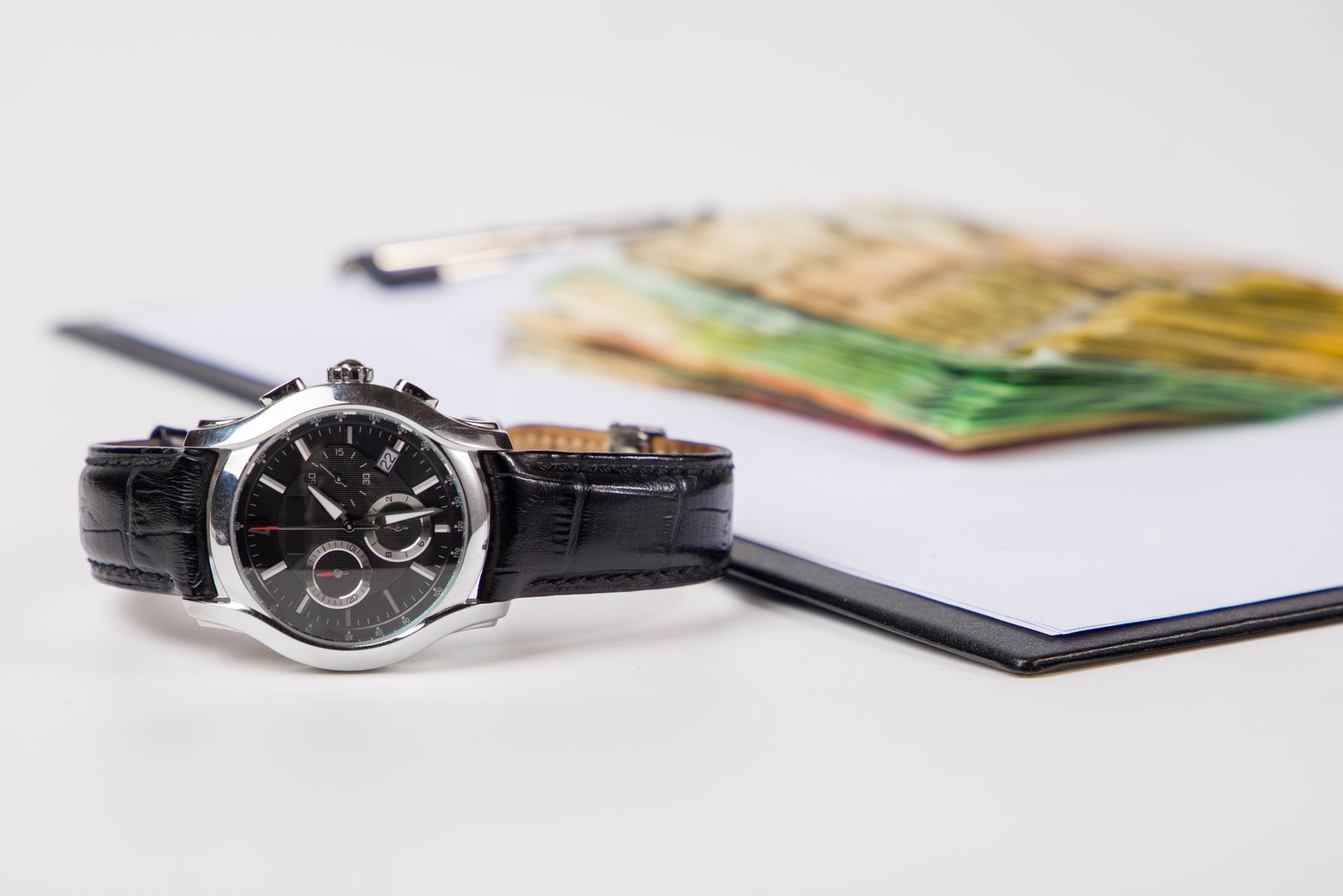 a closeup of a wristwatch and  and money