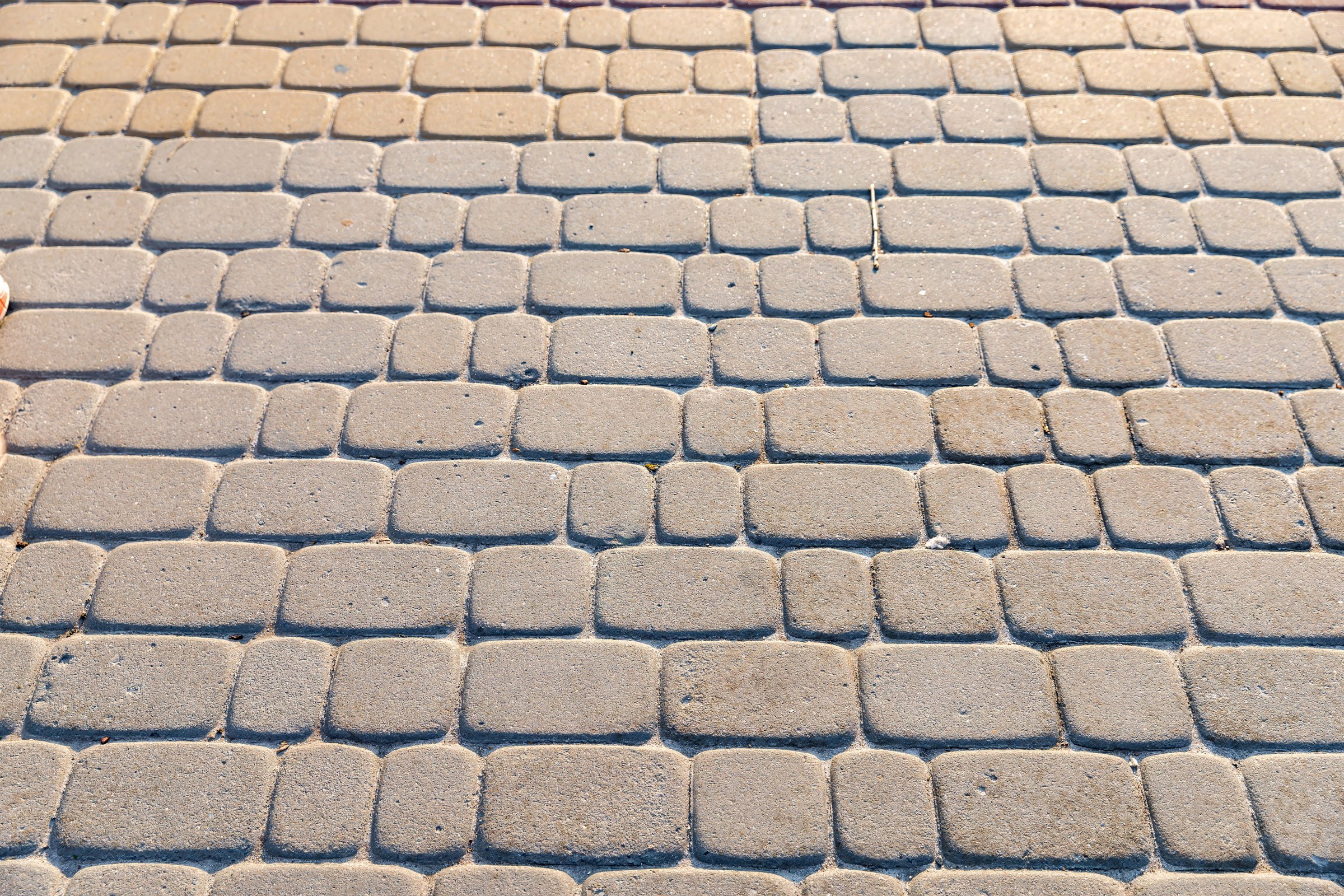 Реальная фотография бетонной тротуарной плитки, уложенной в прямоугольный узор. Городской фон и архитектурная текстура, подходящая для дизайна, строительства и 3D-проектов.