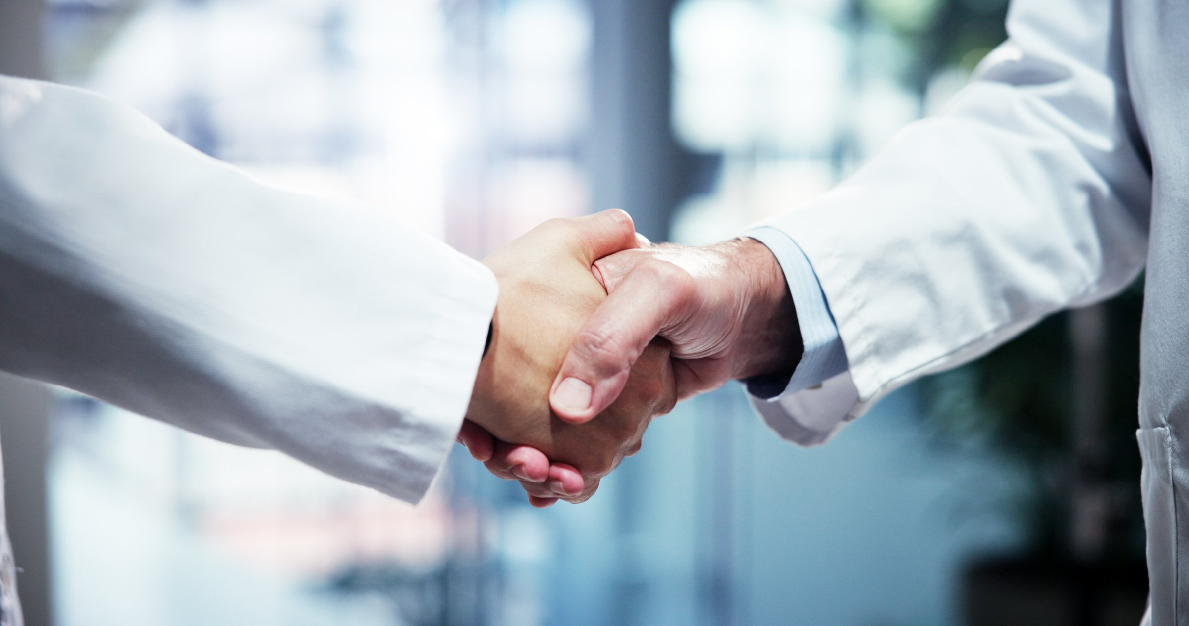 People, scientist or greeting with handshake for partnership, medical agreement or deal at hospital. Closeup, teamwork or health employees shaking hands with meeting for research, b2b or clinic trial