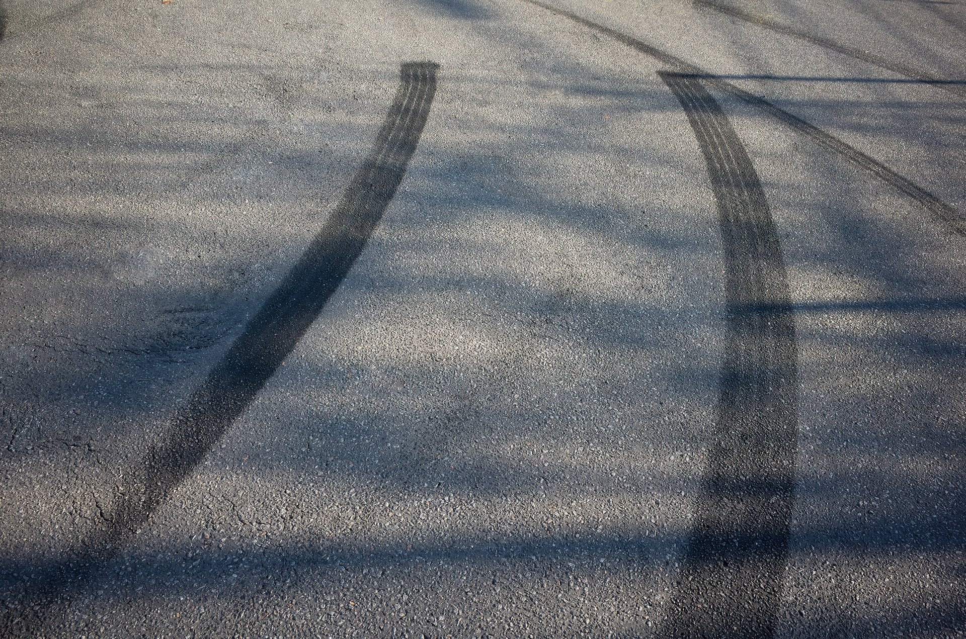 scuff marks, tire marks, acceleration marks, braking marks on an asphalt road