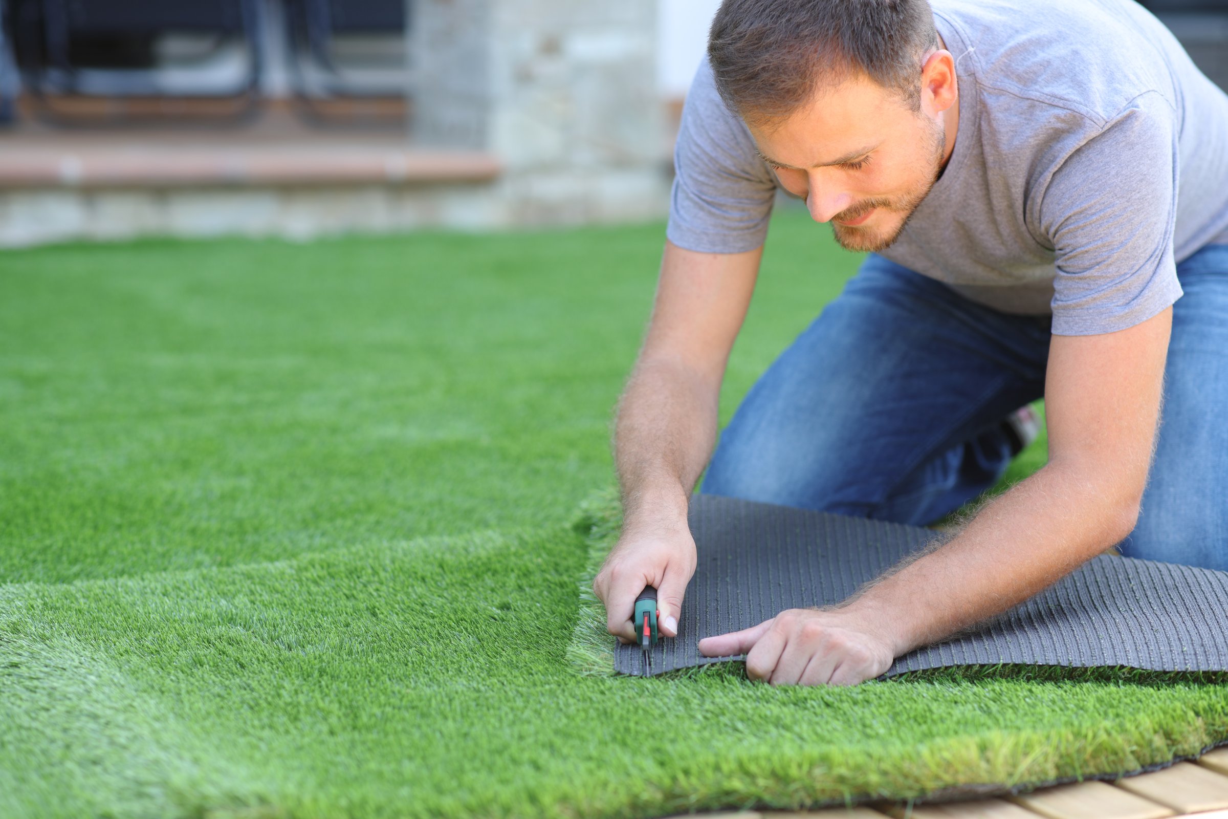 Man installing and cutting artifial turf