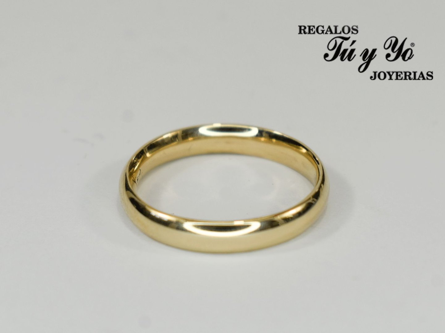 Gold wedding band on a white background with 'Regalos Tú y Yo Joyerias' text in the top right corner.