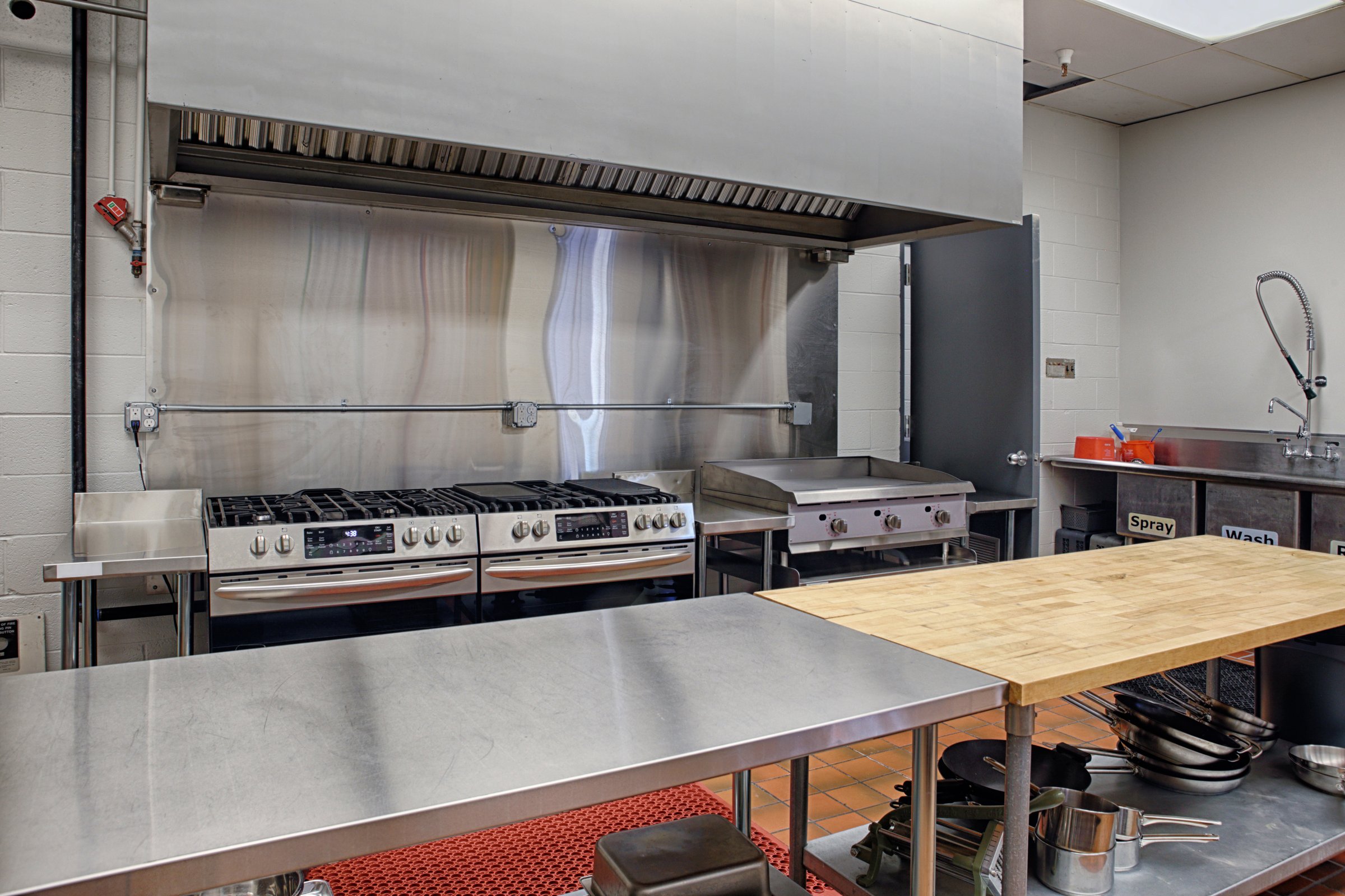 A modern stainless steel kitchen with wash area and prep tables for culinaty arts classes in a modern Technical Careers High School .