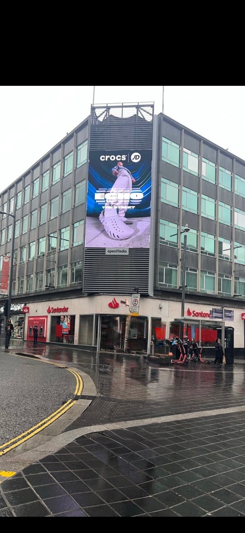 Footwear model showcasing Crocs shoes in global billboard fashion campaign