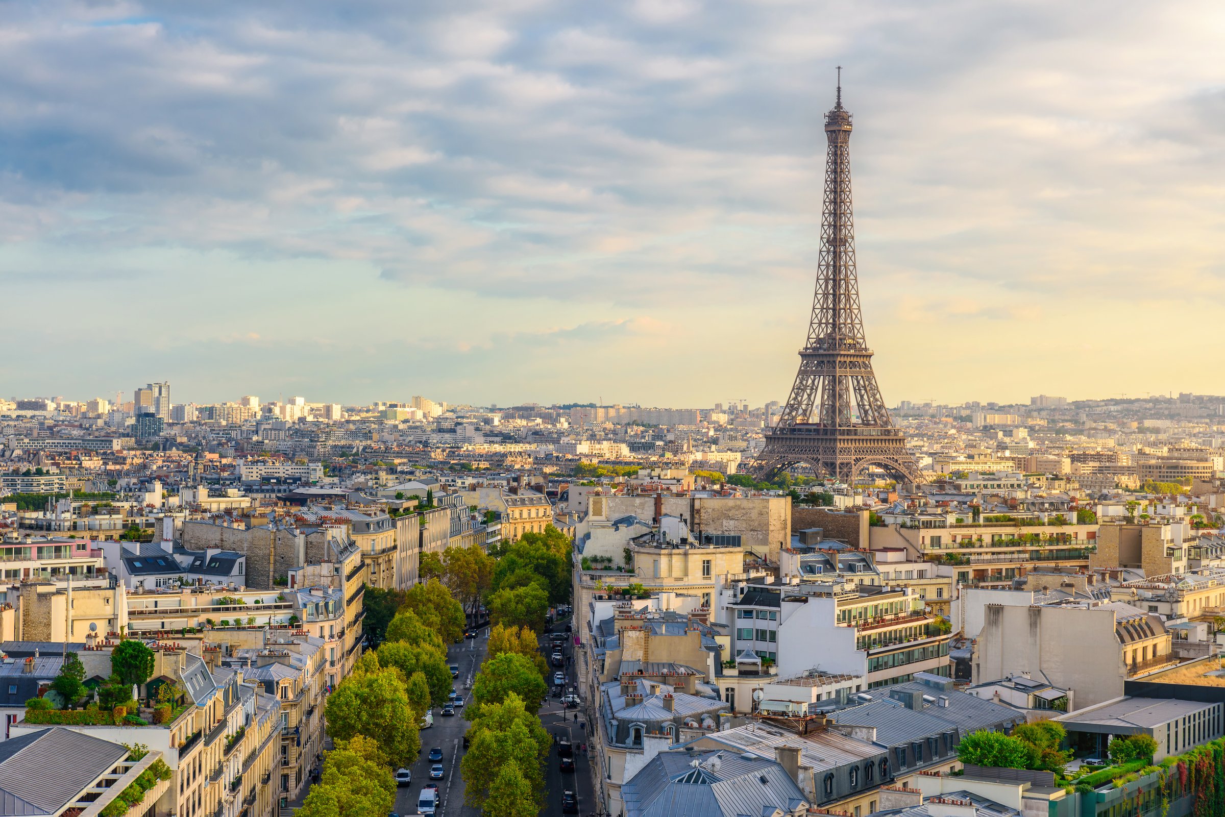 Aerial view of Paris with Eiffel Tower and Champs Elysees from the roof of the Triumphal Arch. Panoramic sunset view of old town of Paris. City skyline. Popular travel destination.