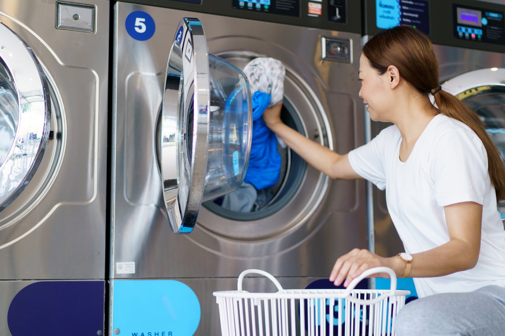 Woman using self-service laundry machine