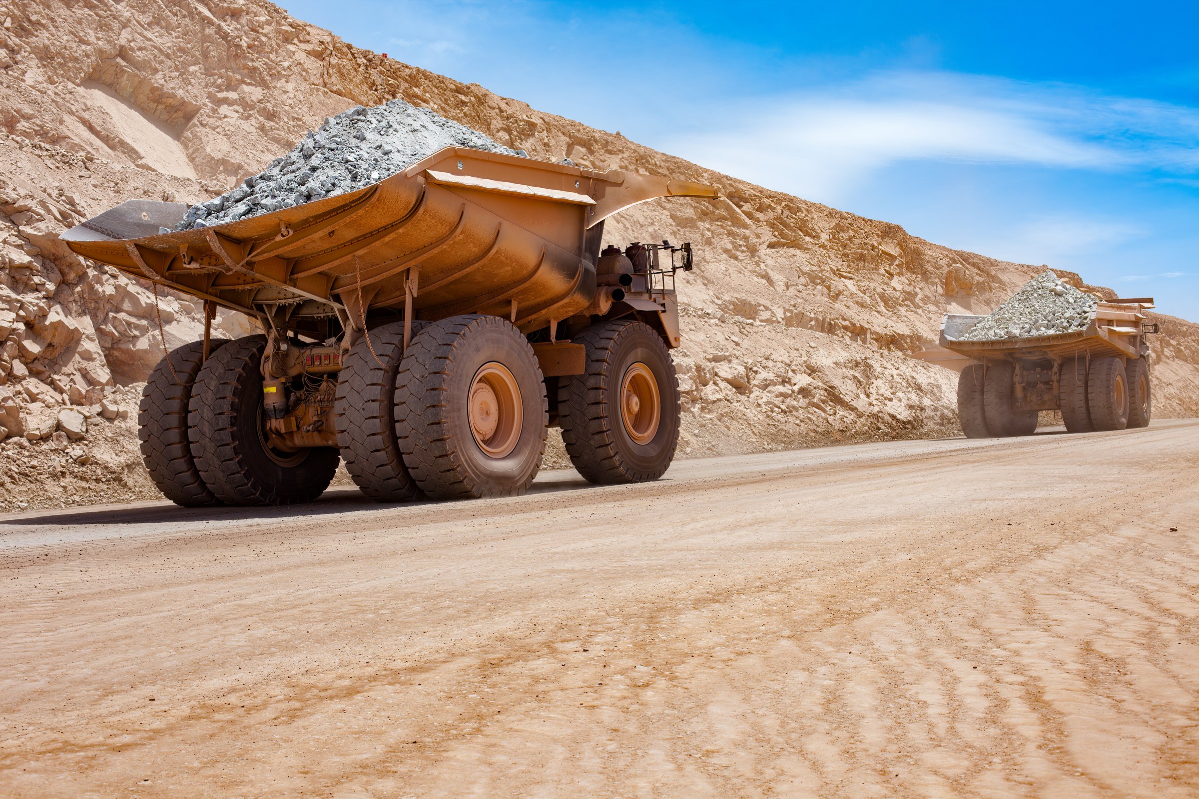 Dump trucks at open-pit mine loading chrome ore